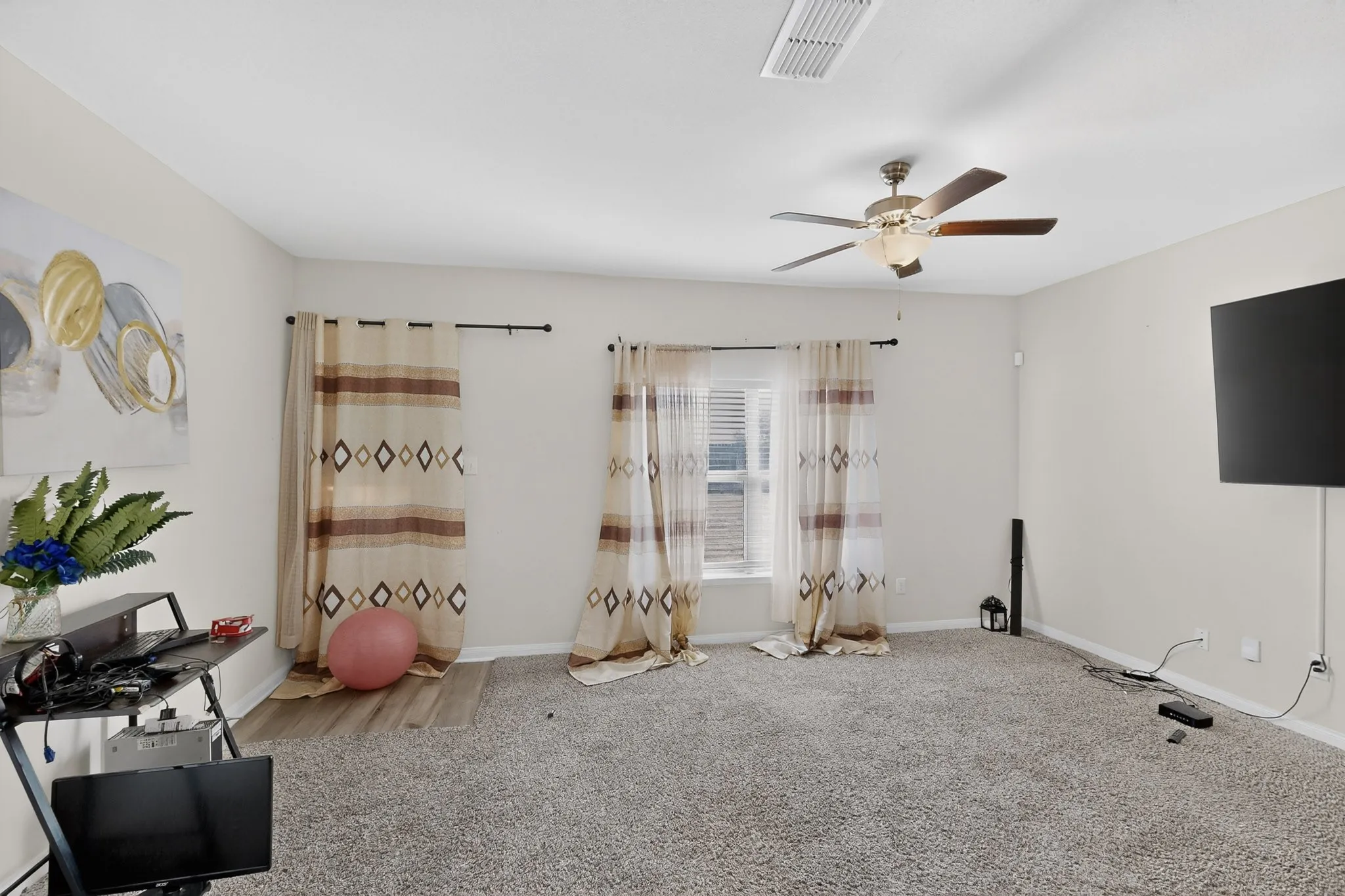 Exercise room with carpet and a ceiling fan