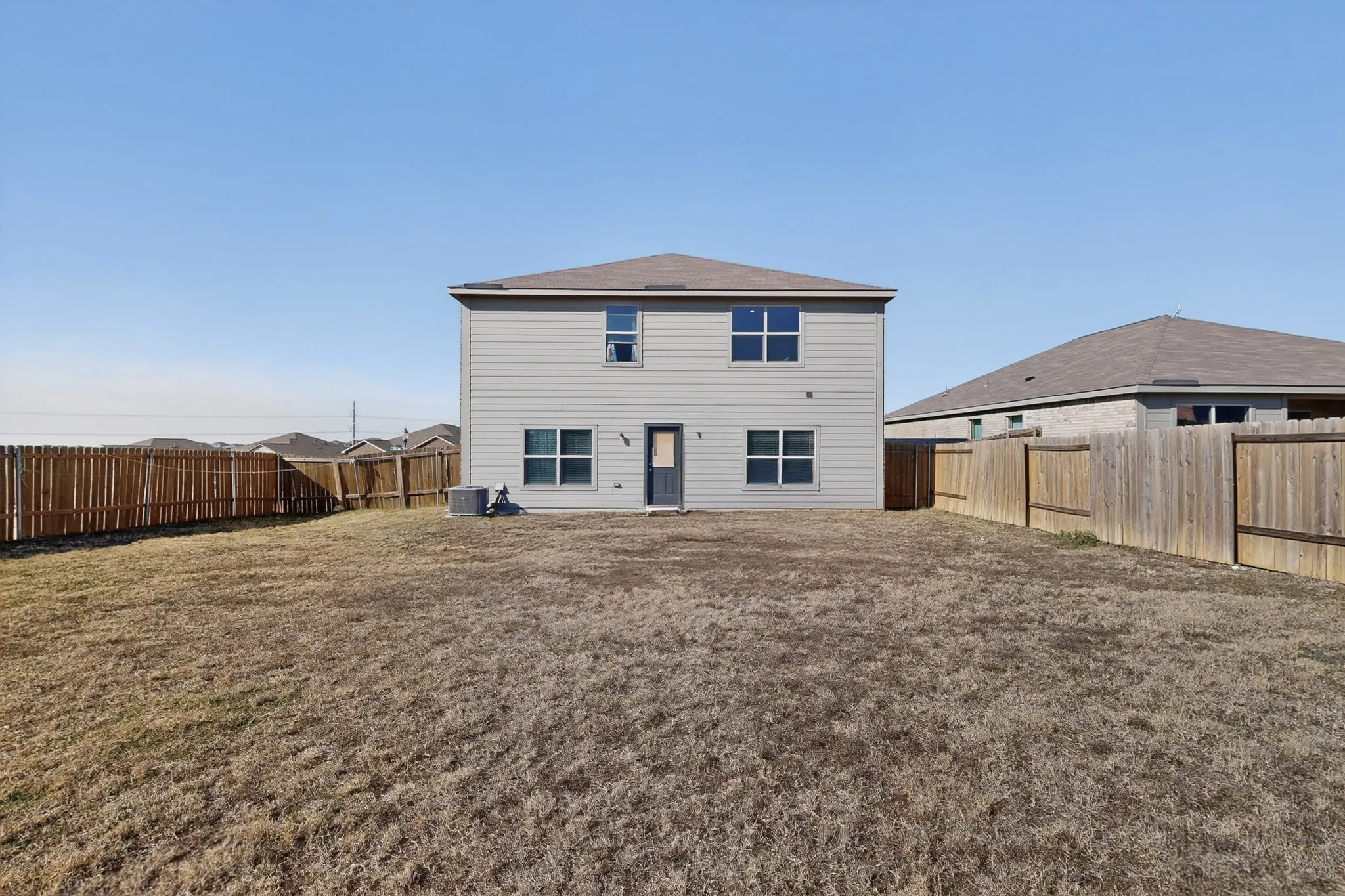 Rear view of house with a fenced backyard