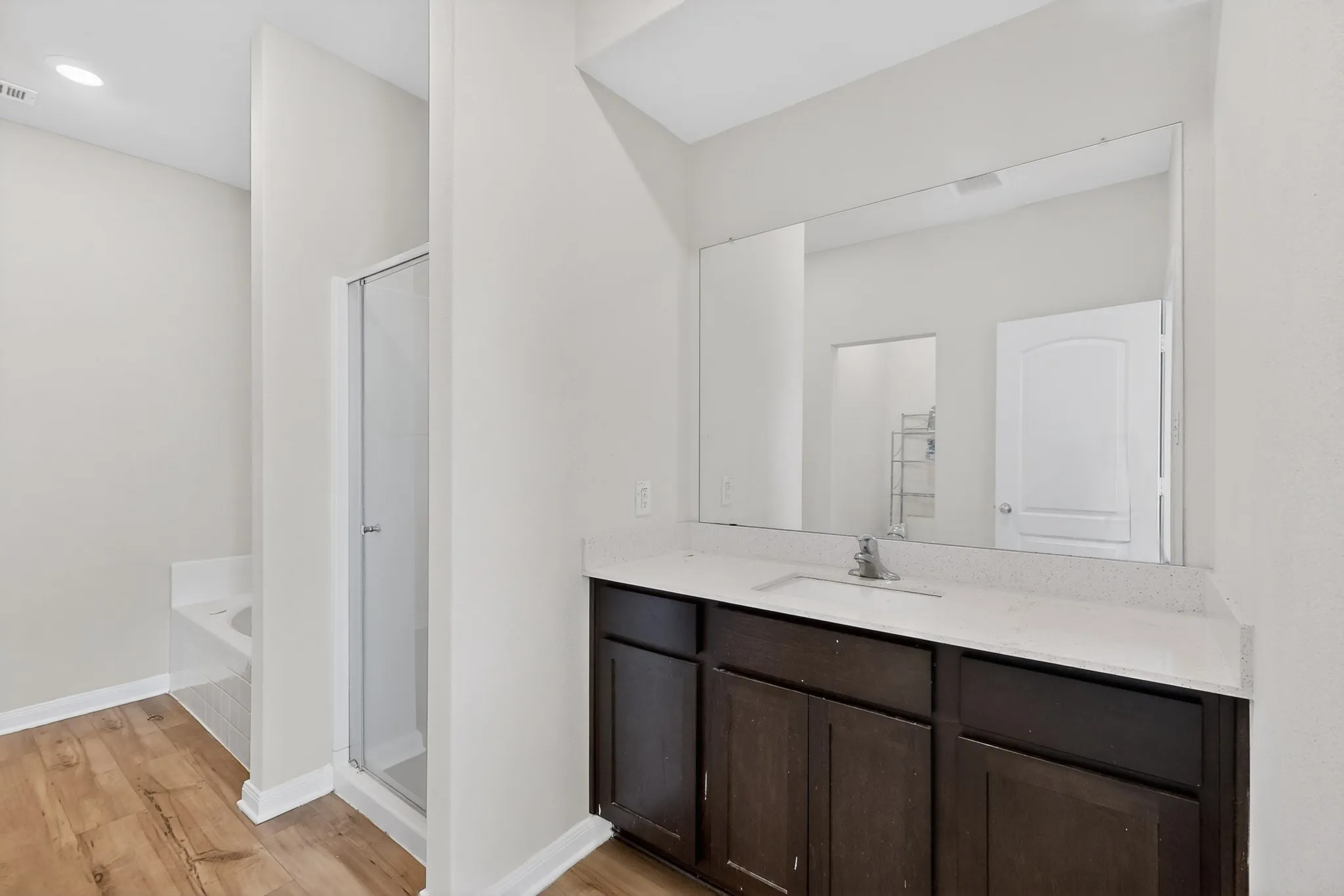 Bathroom with a stall shower, vanity, a bath, and light wood finished floors