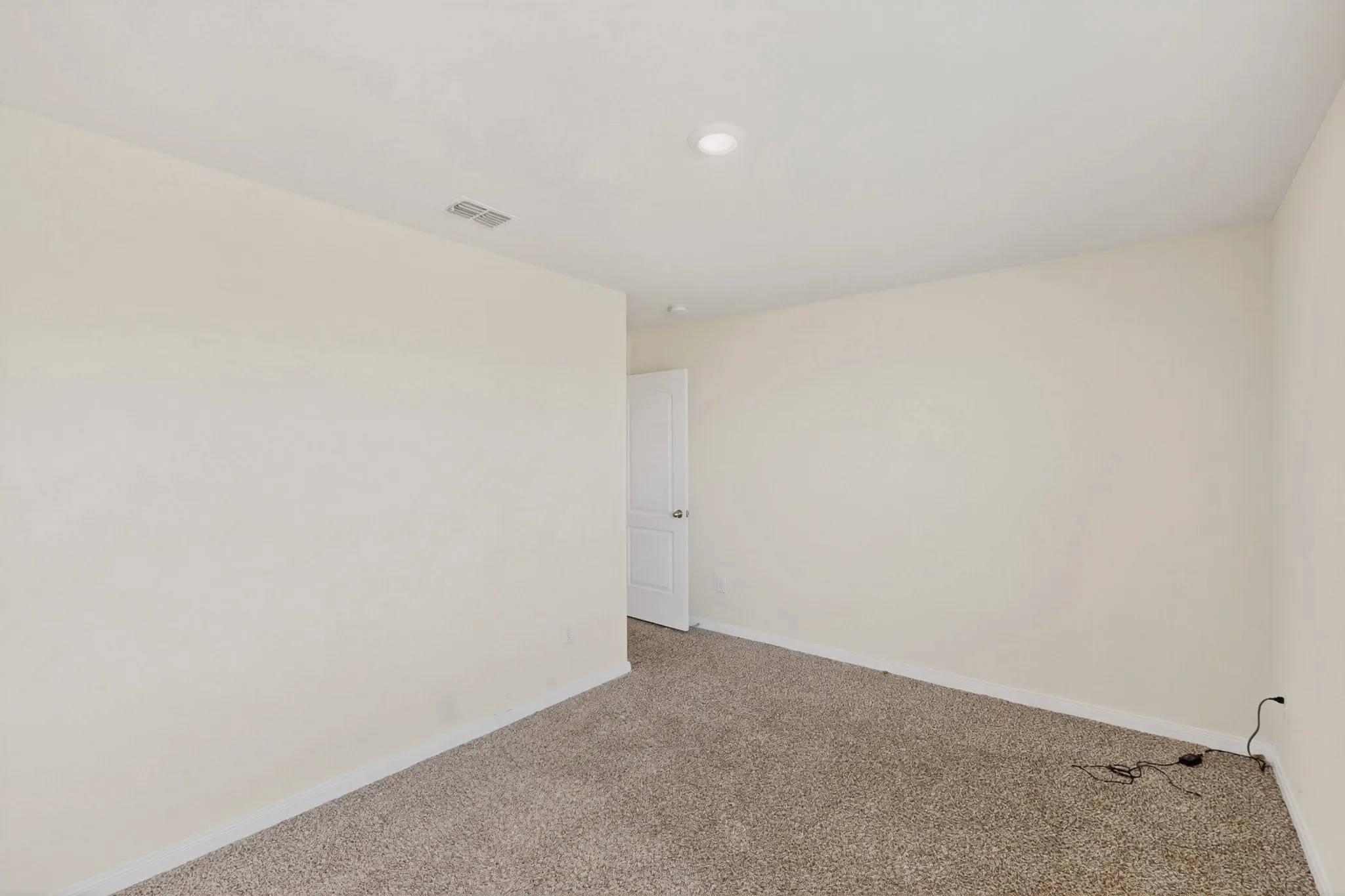 Carpeted spare room featuring baseboards