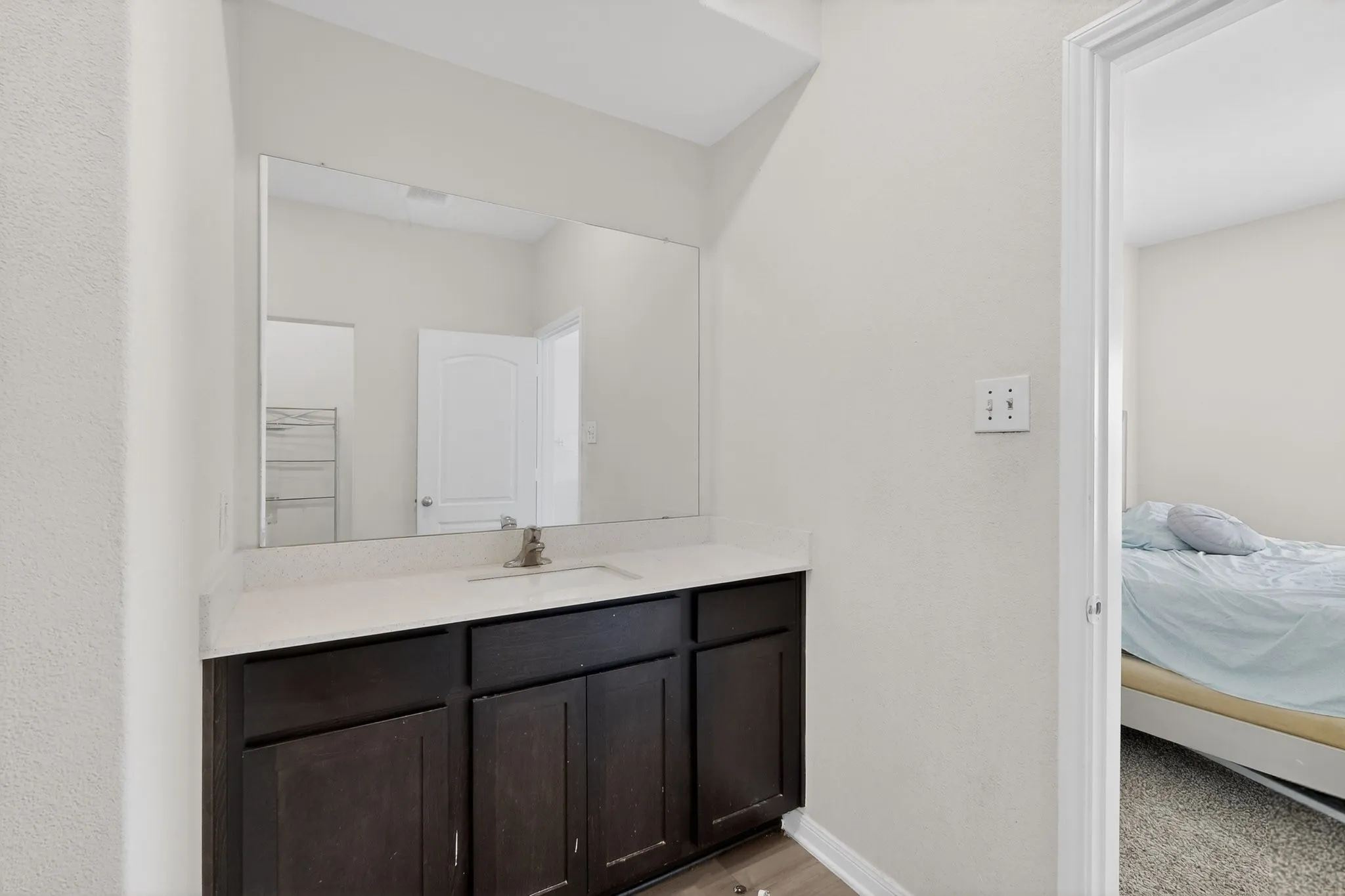 Ensuite bathroom featuring vanity and baseboards