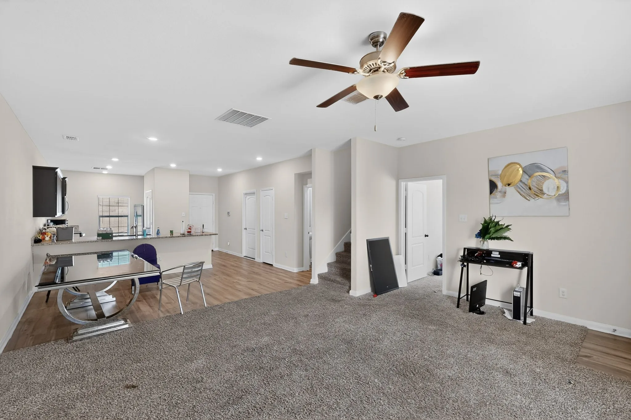 Office space with light colored carpet, a ceiling fan, and recessed lighting