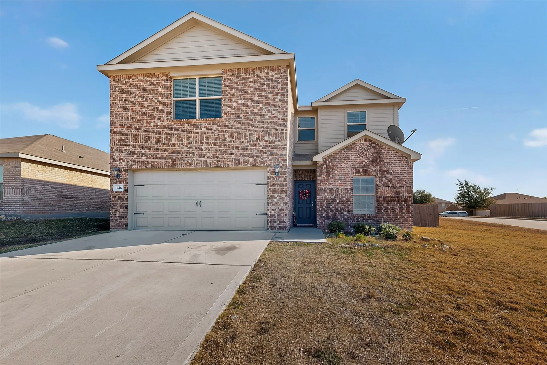 Traditional home with concrete driveway, brick siding, and a garage