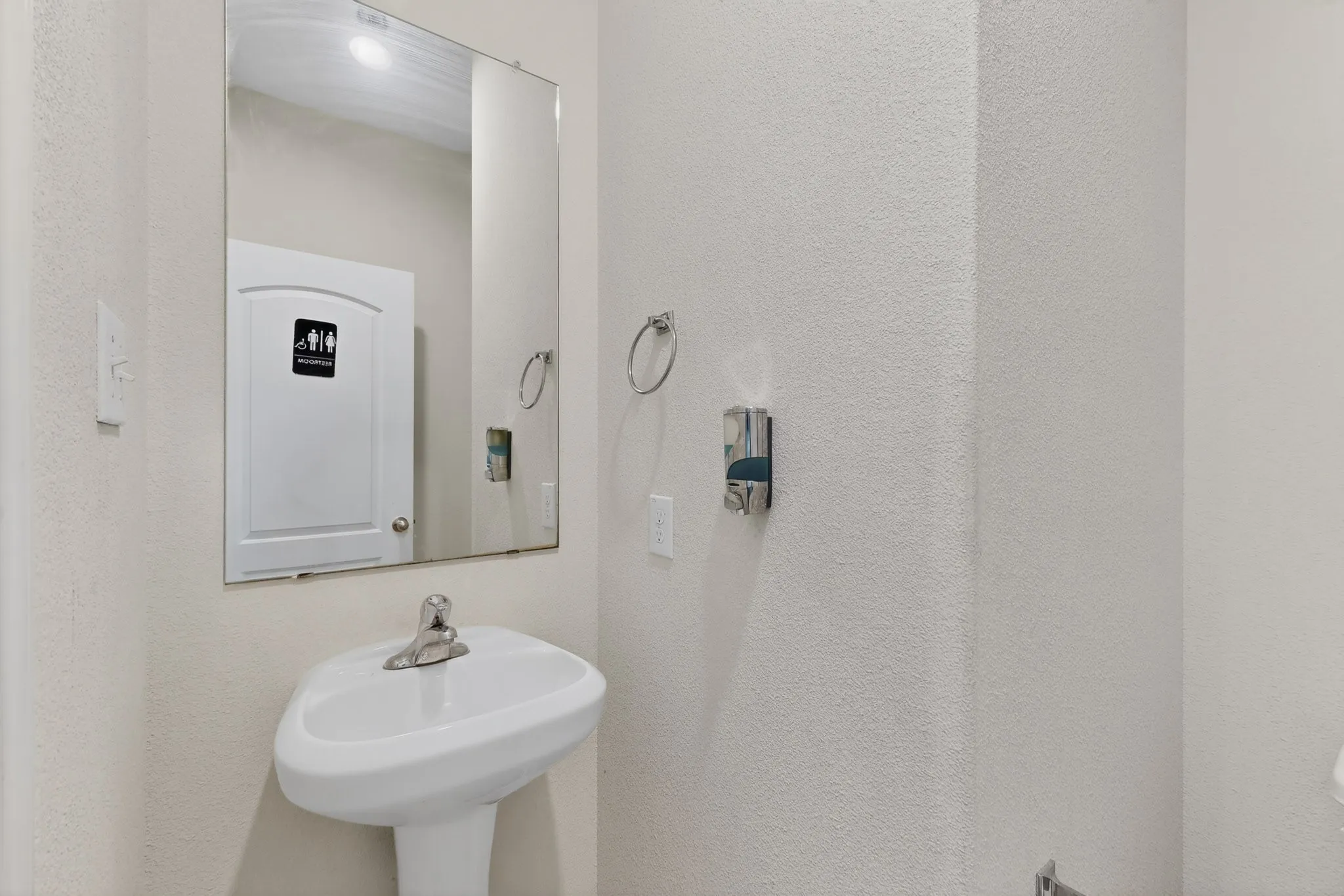 Half bath featuring a textured wall
