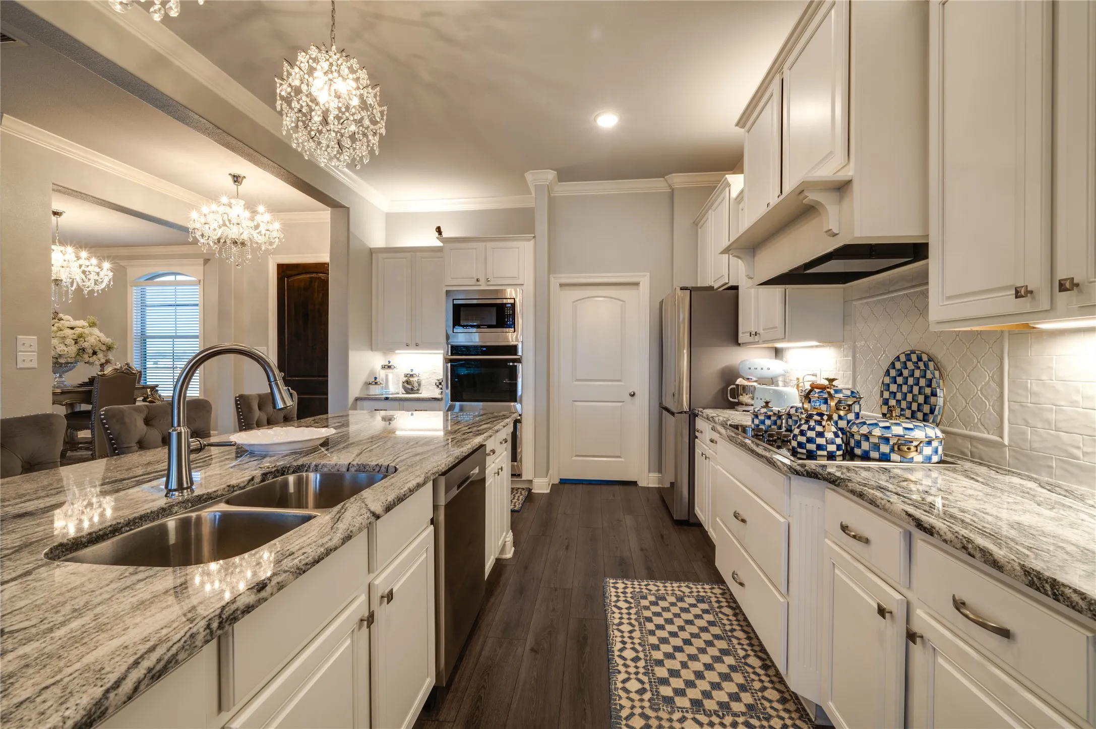 Chefs kitchen with custom cabinetry, granite counters, electric stovetop, double ovens, dishwasher and microwave. Large walk in pantry.
