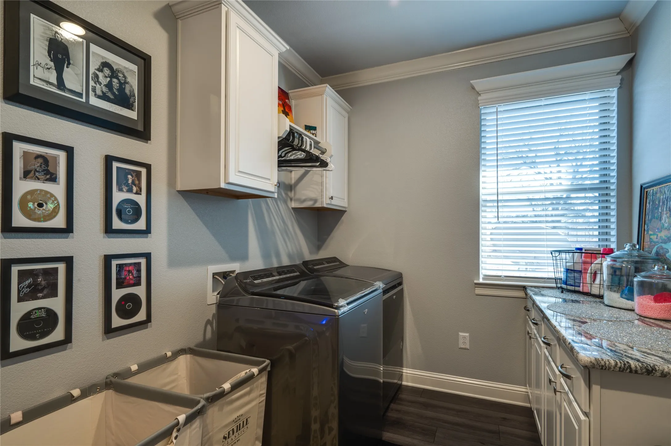 Laundry room with upper and lower cabinetry. Granite countertops.
