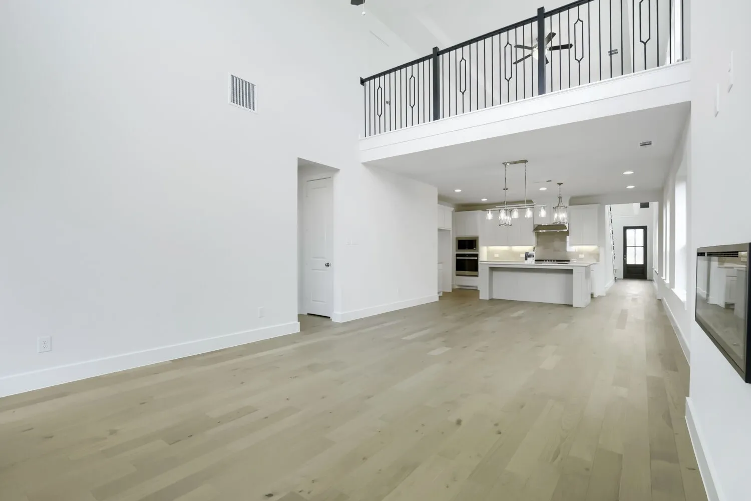 Spacious open-concept living area with light wood-finish flooring
