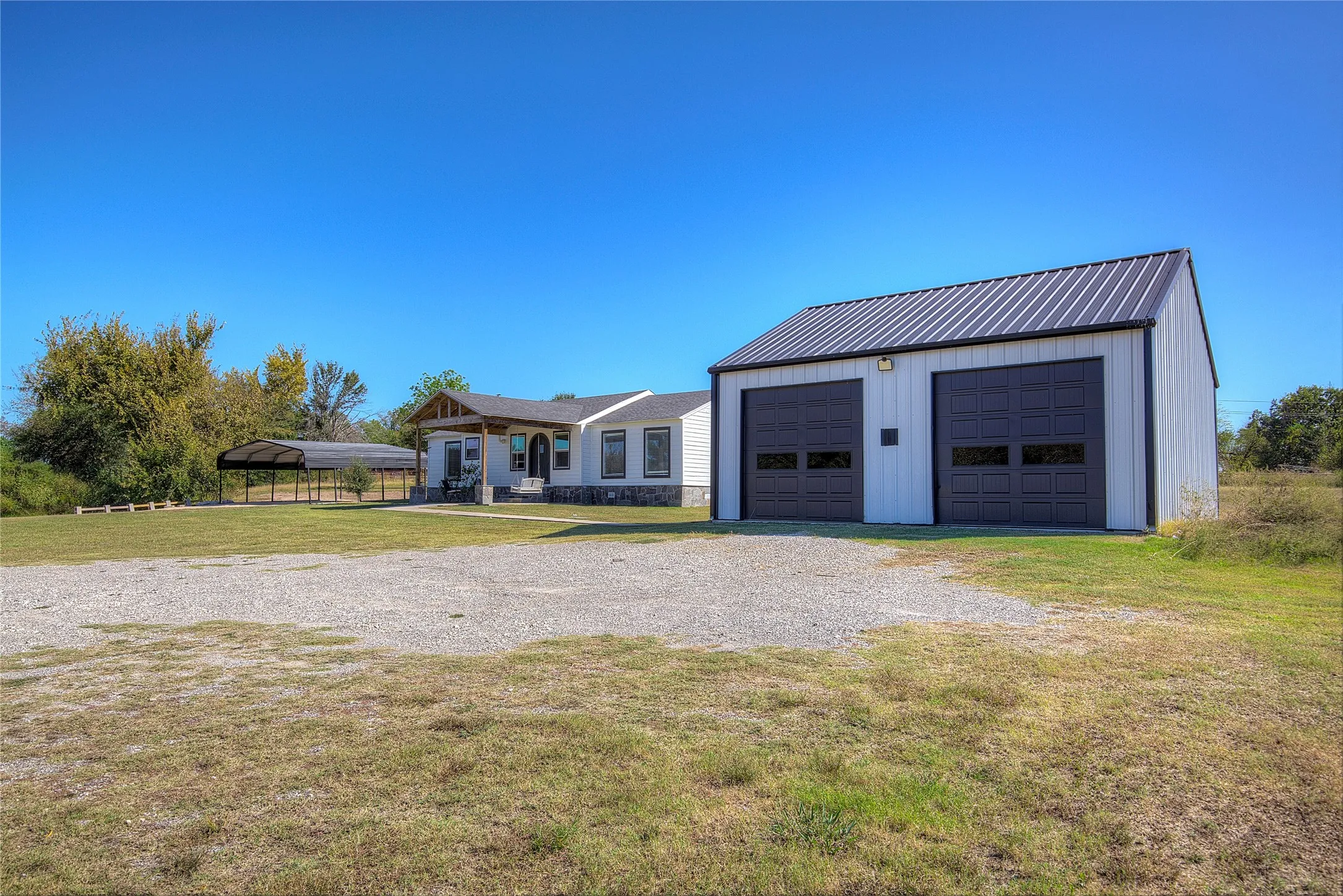 View of garage, house and detached carport