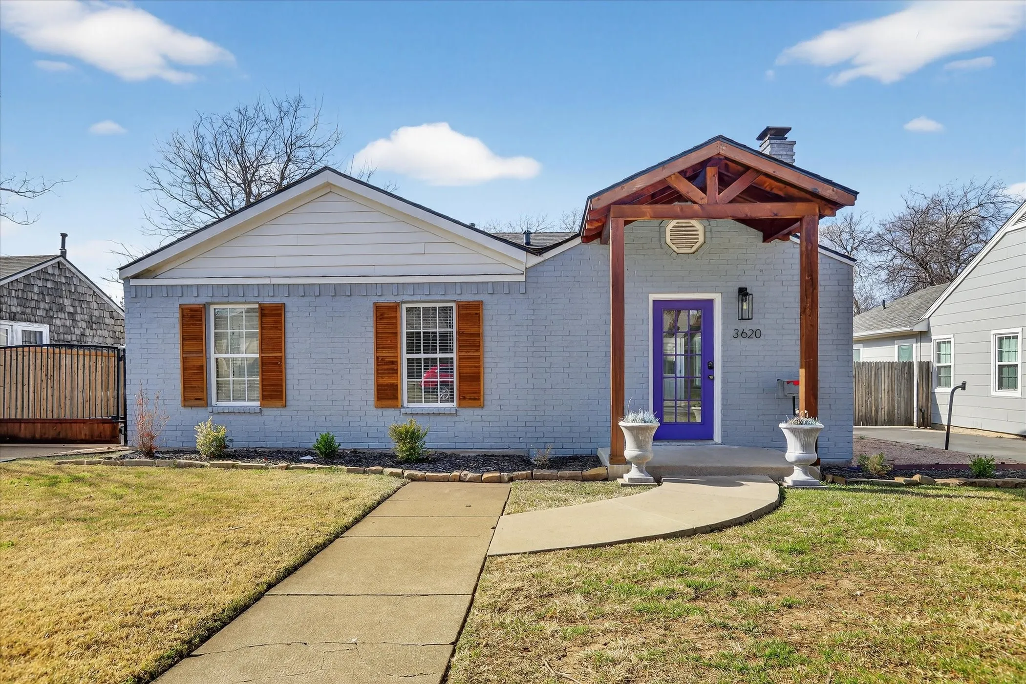 Covered front porch, flower beds with stone border, and beautiful cedar details.