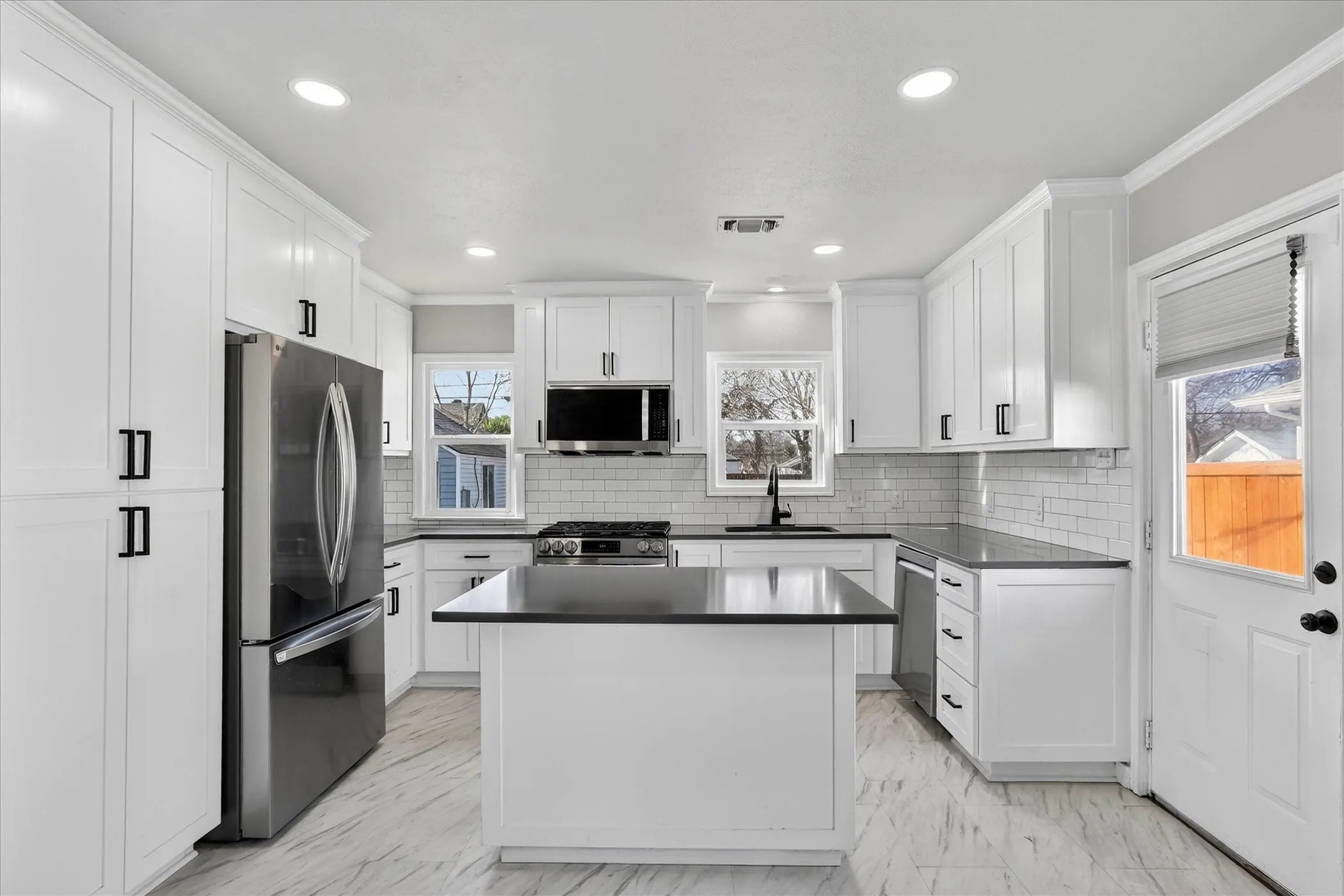 Wonderful updated kitchen with white cabinetry, pantry, quartz countertops, lots of natural light, built in microwave, refrigerator and gas range.