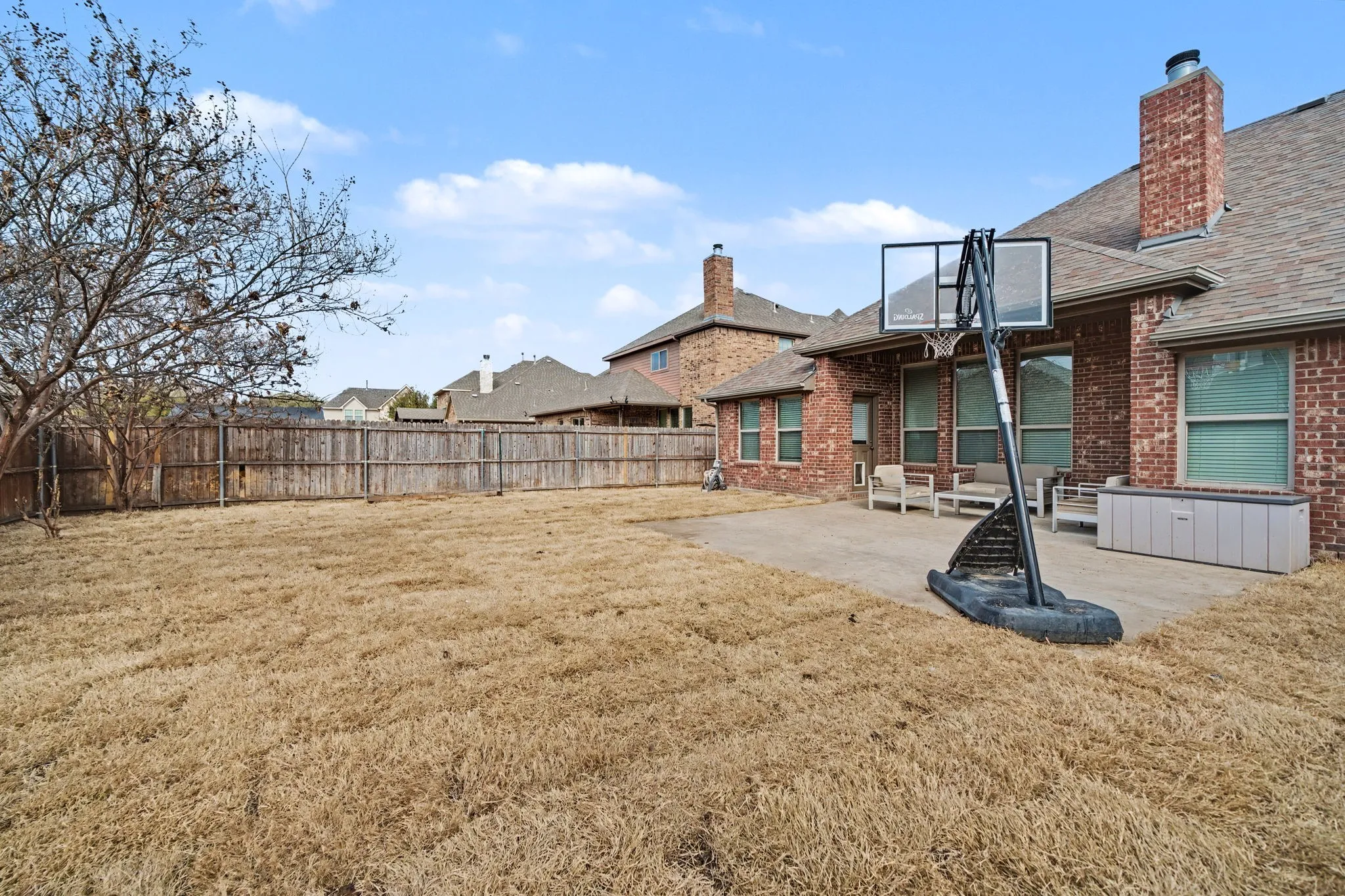 Fenced backyard featuring a patio and a residential view