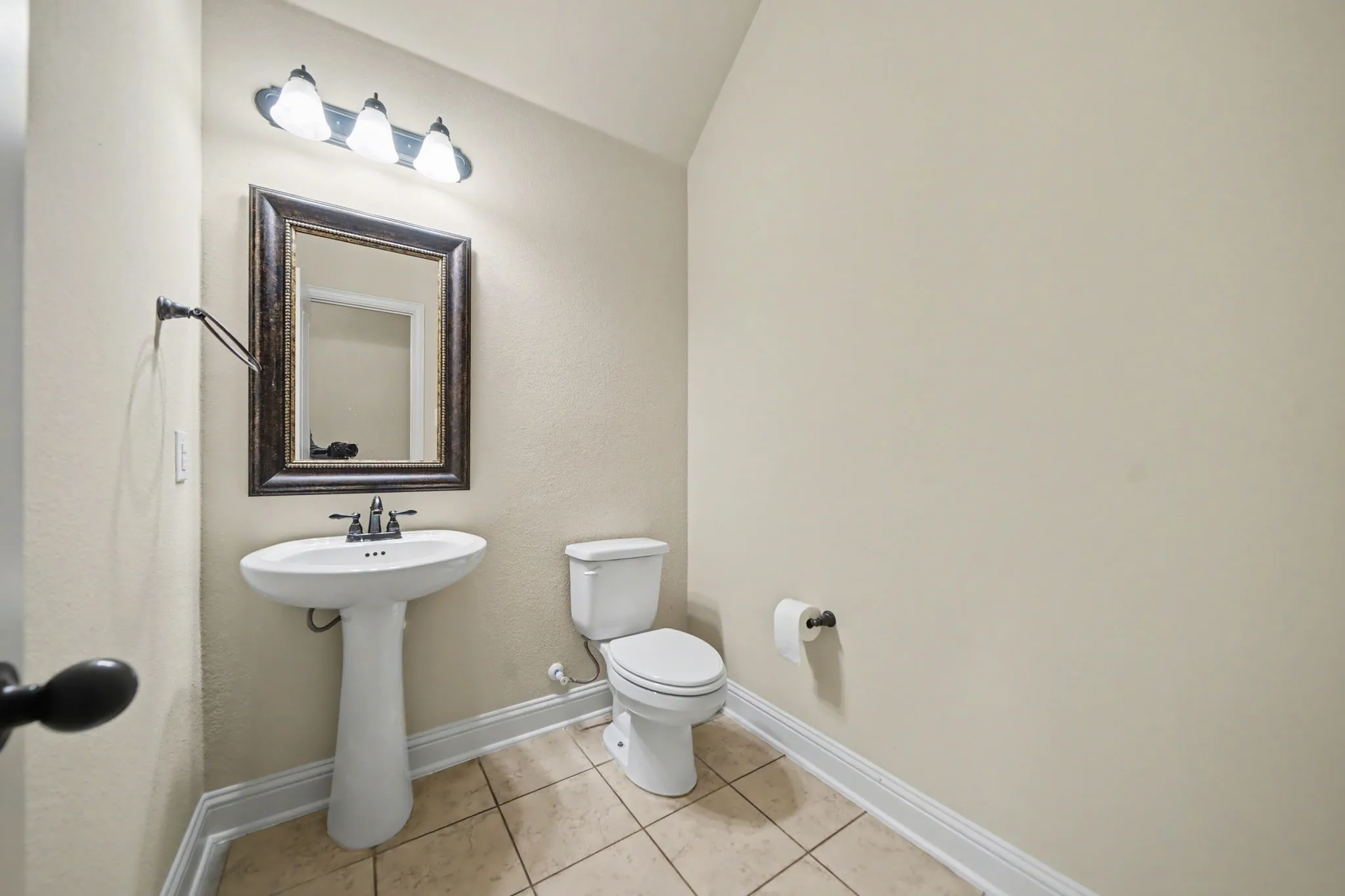 Bathroom featuring light tile patterned floors and lofted ceiling