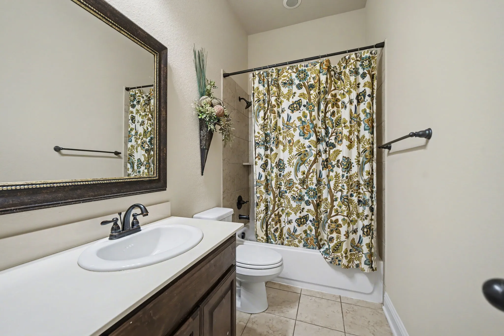 Full bathroom with shower / bath combination with curtain, vanity, and light tile patterned floors