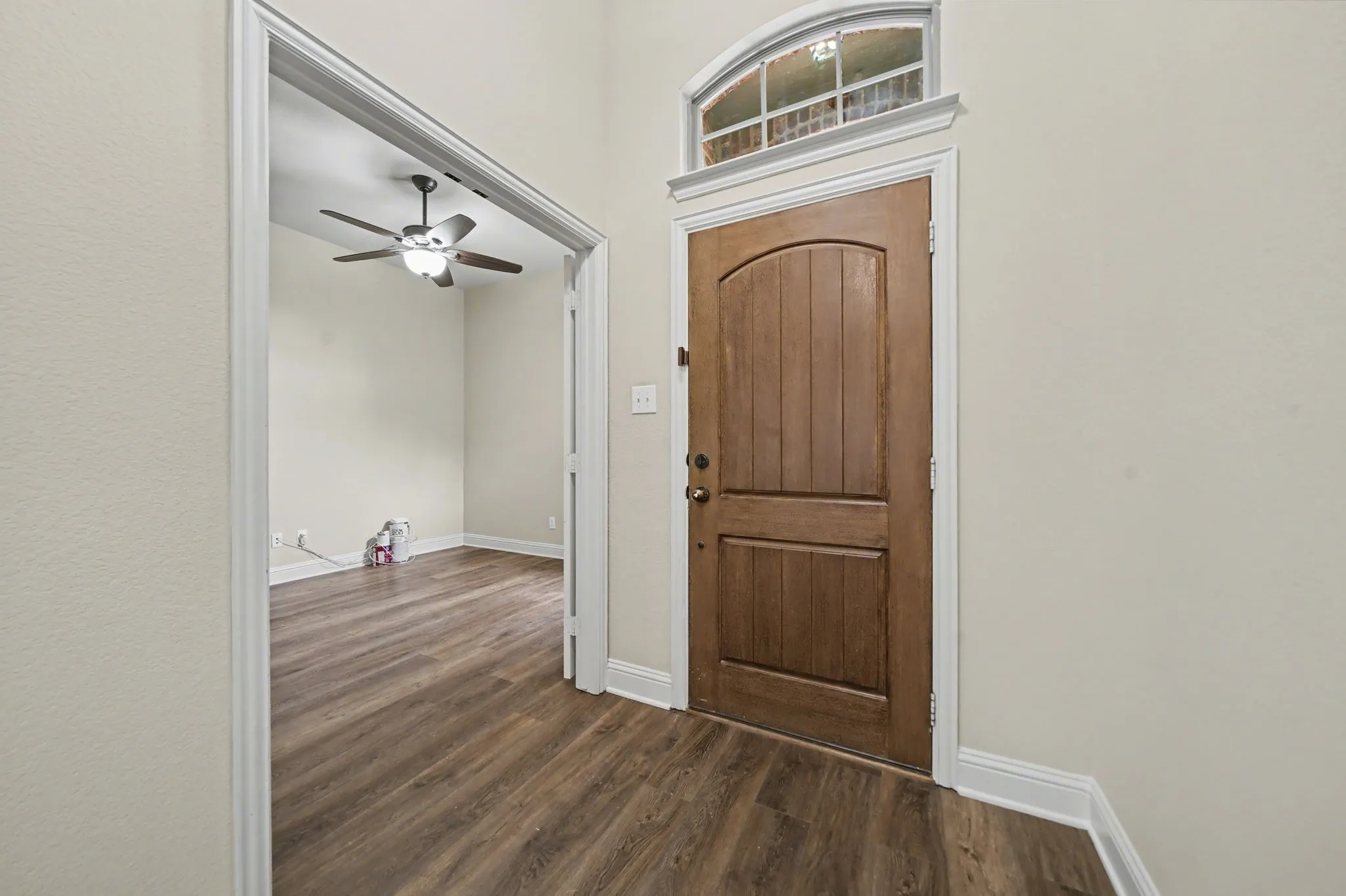Foyer featuring ceiling fan, dark wood-type flooring, and a towering ceiling