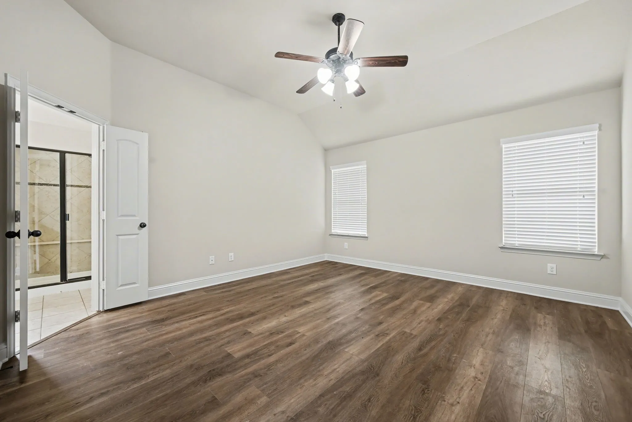 Unfurnished room with dark wood finished floors, lofted ceiling, and a ceiling fan