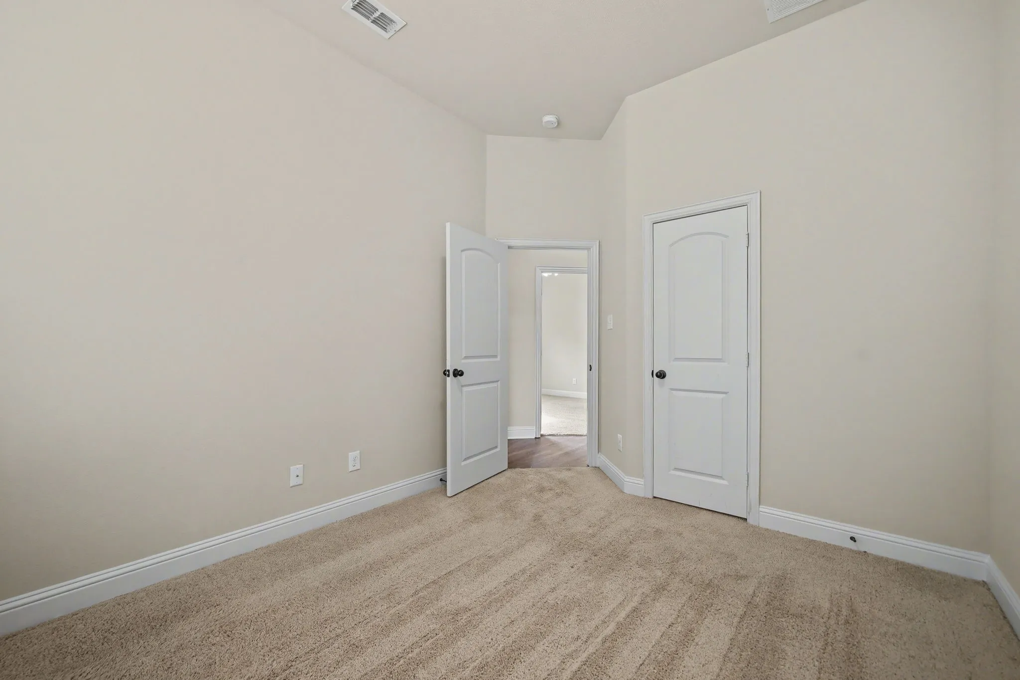 Unfurnished bedroom featuring light carpet and baseboards