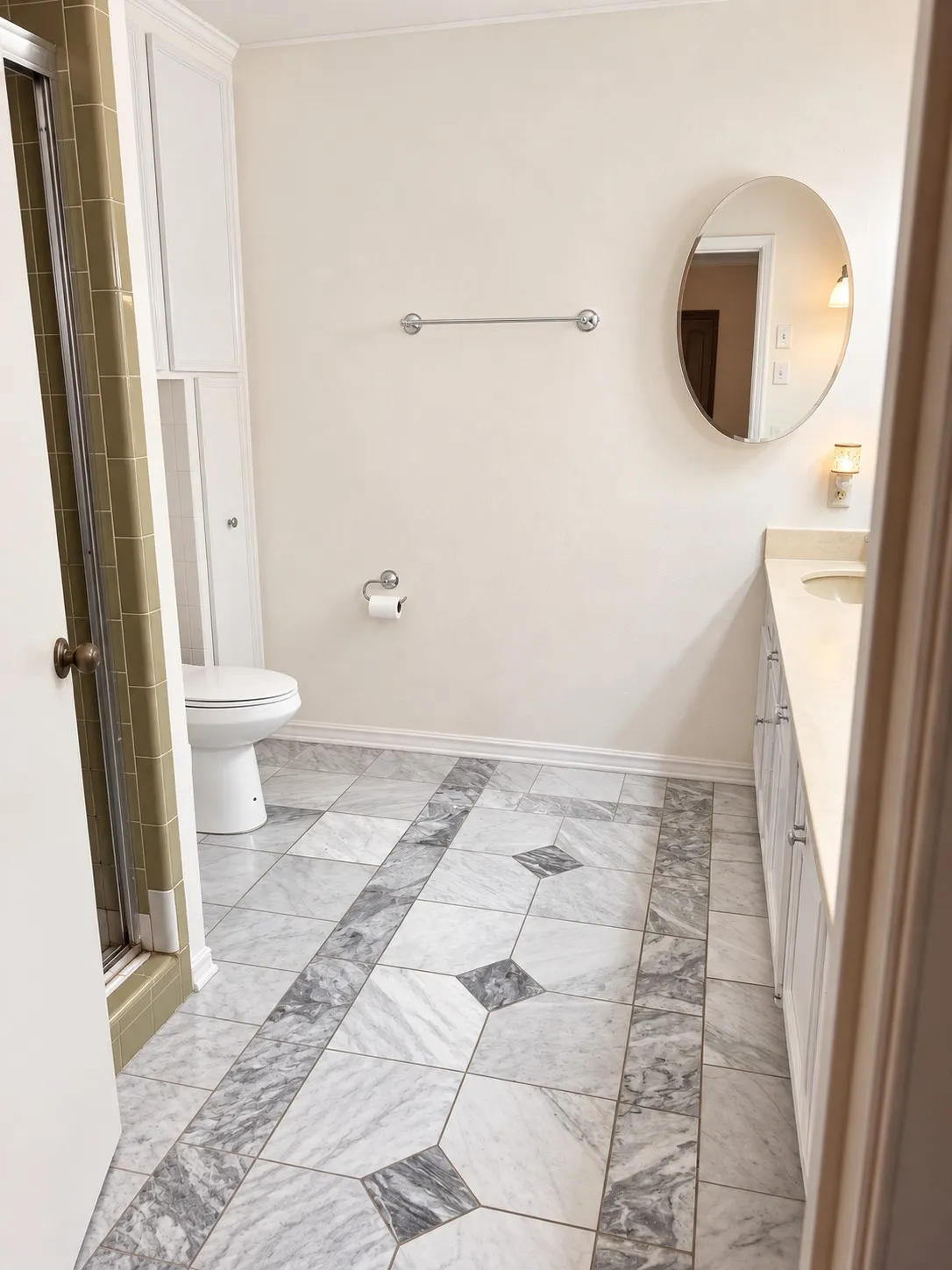 Patterned tile flooring, built-in cabinetry, vanity with countertop and integrated sink, wall-mounted mirror, and a toilet