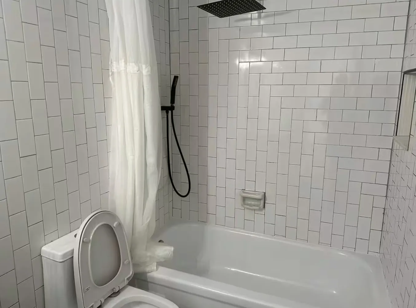 Full bathroom with tiled shower / bath and toilet