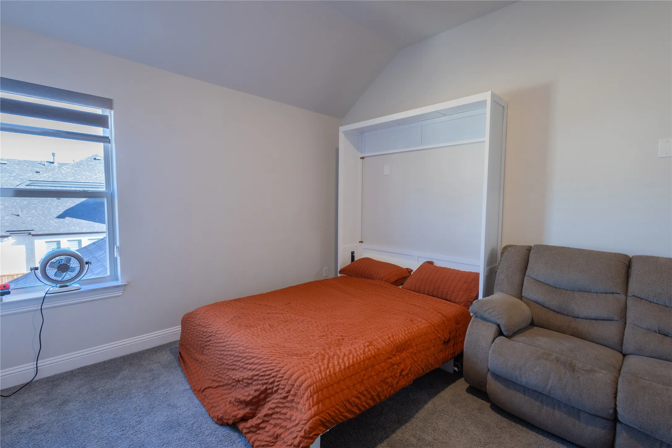Bedroom with vaulted ceiling and carpet