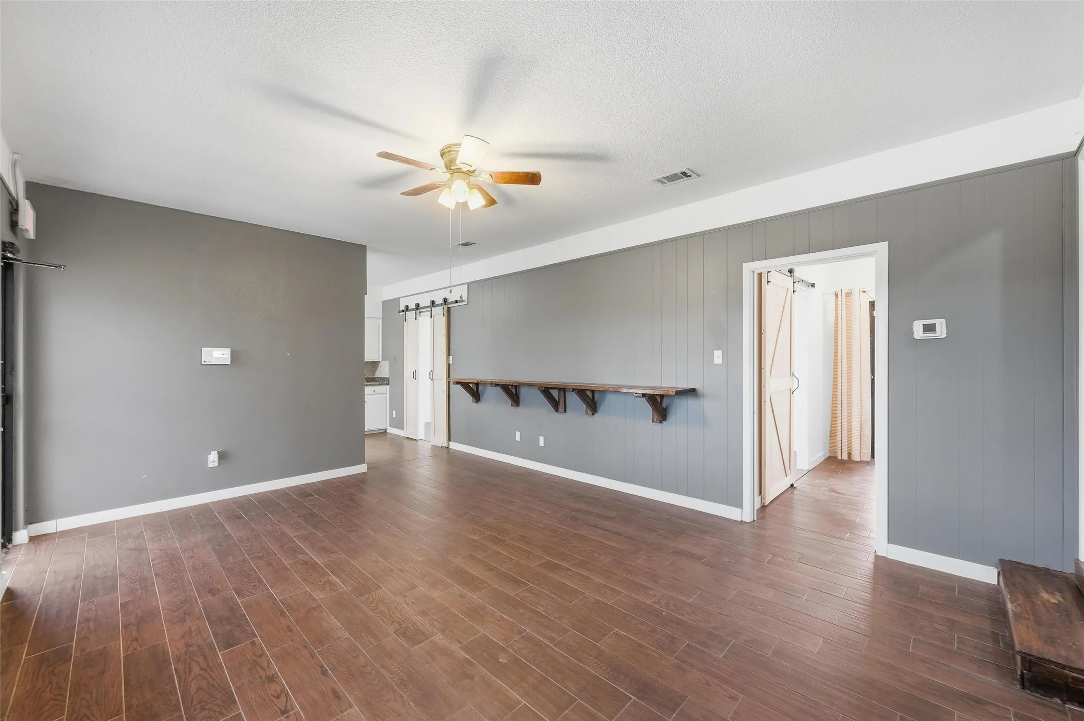 Unfurnished office space featuring a ceiling fan wood finished floors