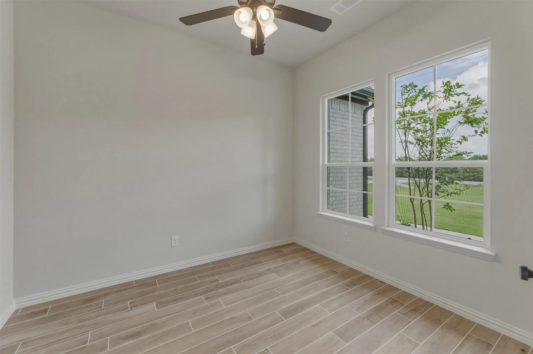 Bright interior space featuring wood-finish plank flooring and white baseboards