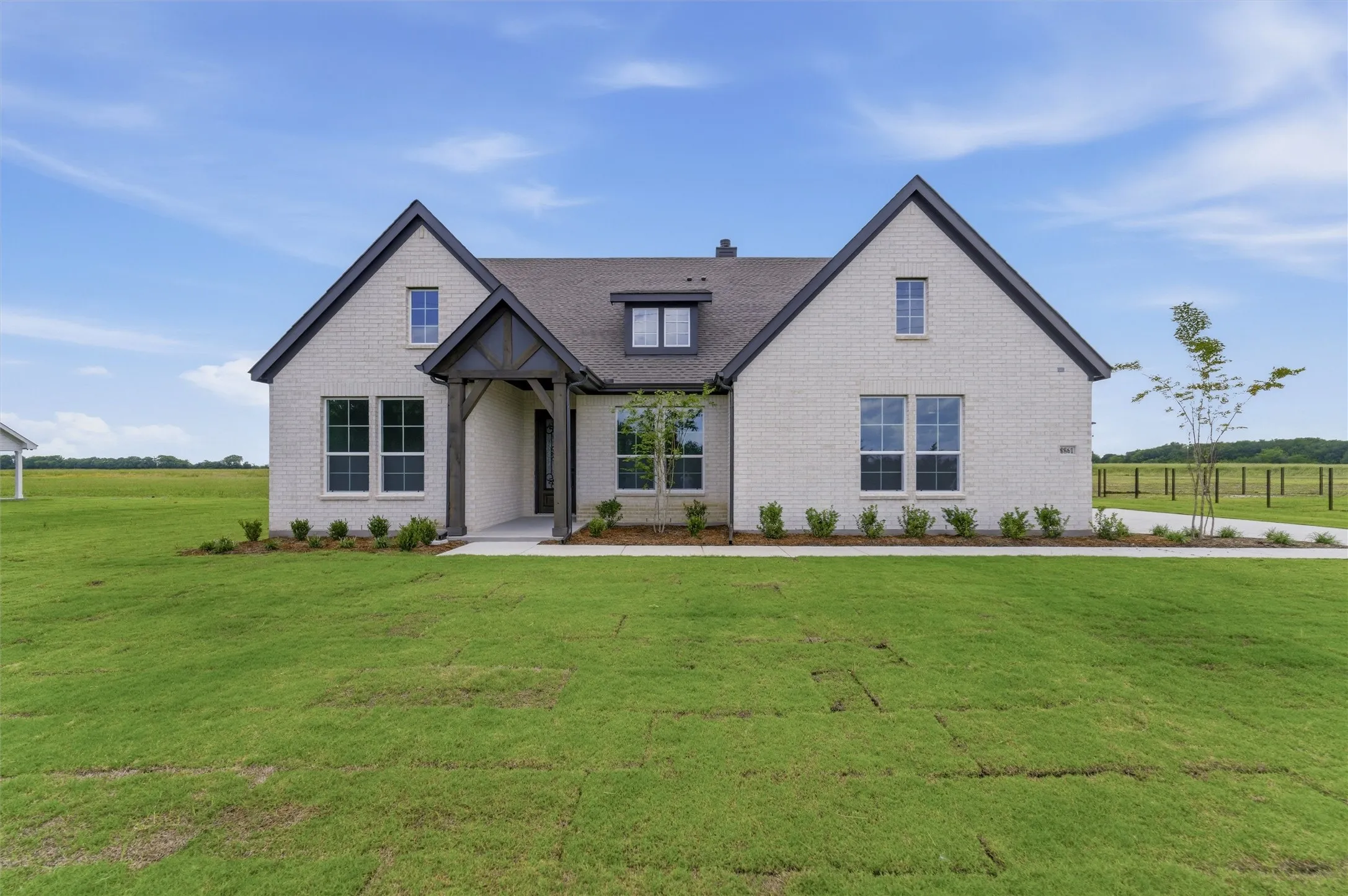Contemporary brick exterior with dark trim accents and a prominent covered entry