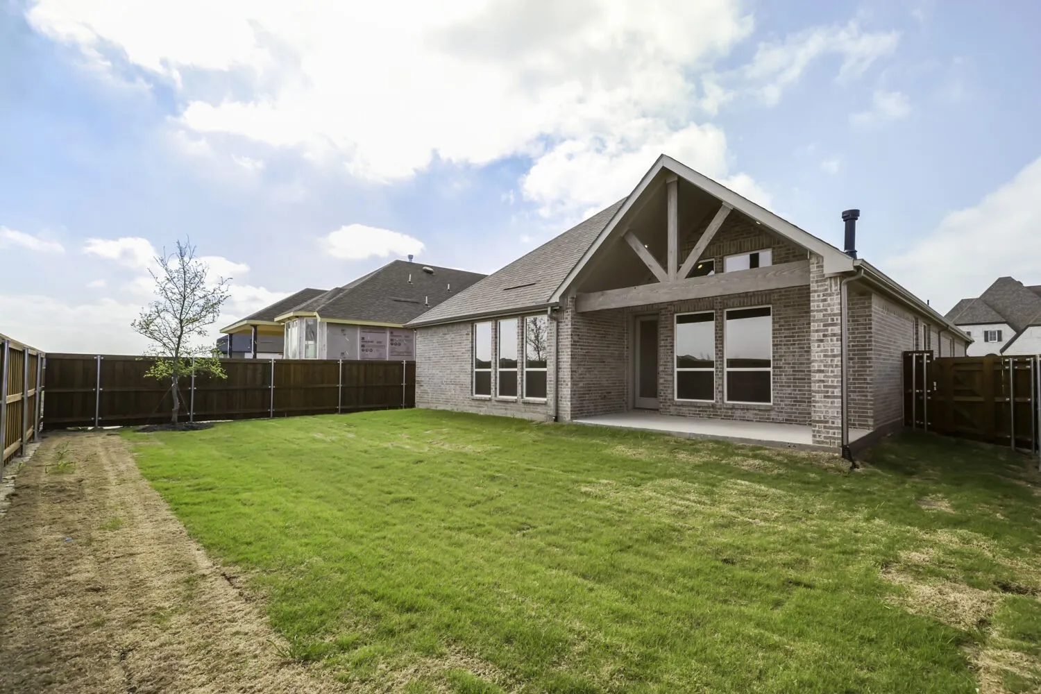 Back of house featuring a patio area, brick siding, and a fenced backyard