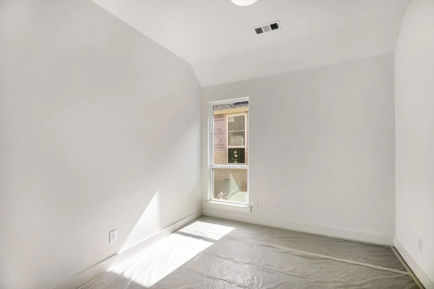 Unfurnished room featuring vaulted ceiling and baseboards