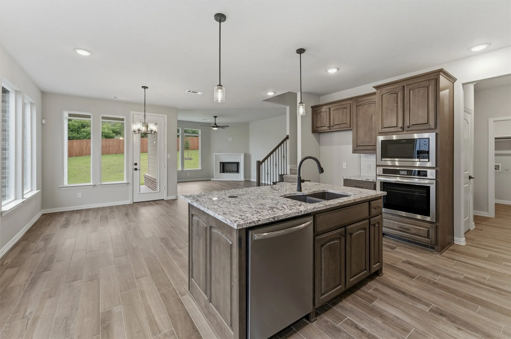 Kitchen island featuring a double-basin sink, stainless steel dishwasher, and pendant lighting