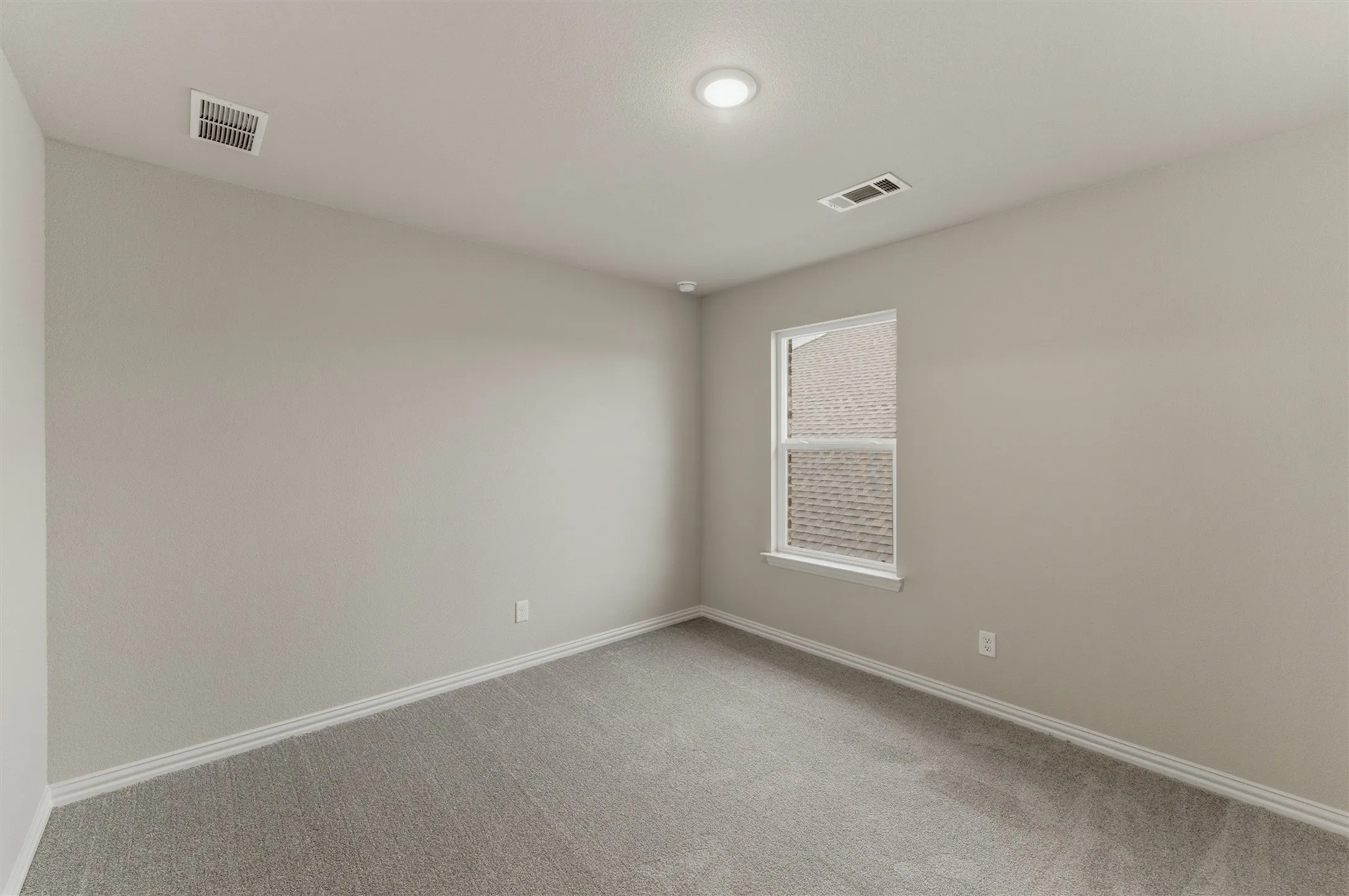 Neutral-toned room featuring a single window, recessed lighting, and light gray carpeting