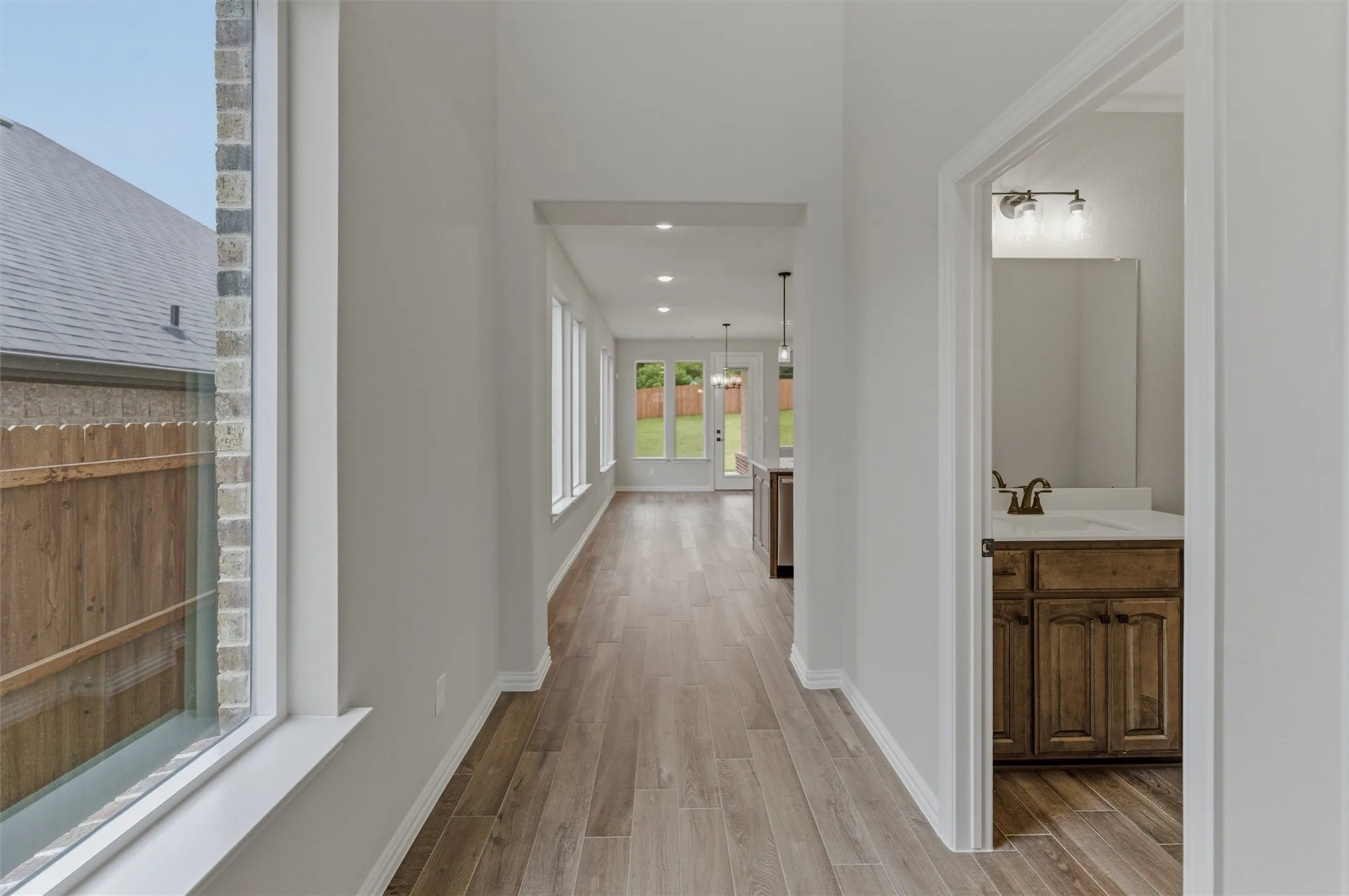 Hallway featuring wood-finish flooring, recessed lighting, and bright white walls