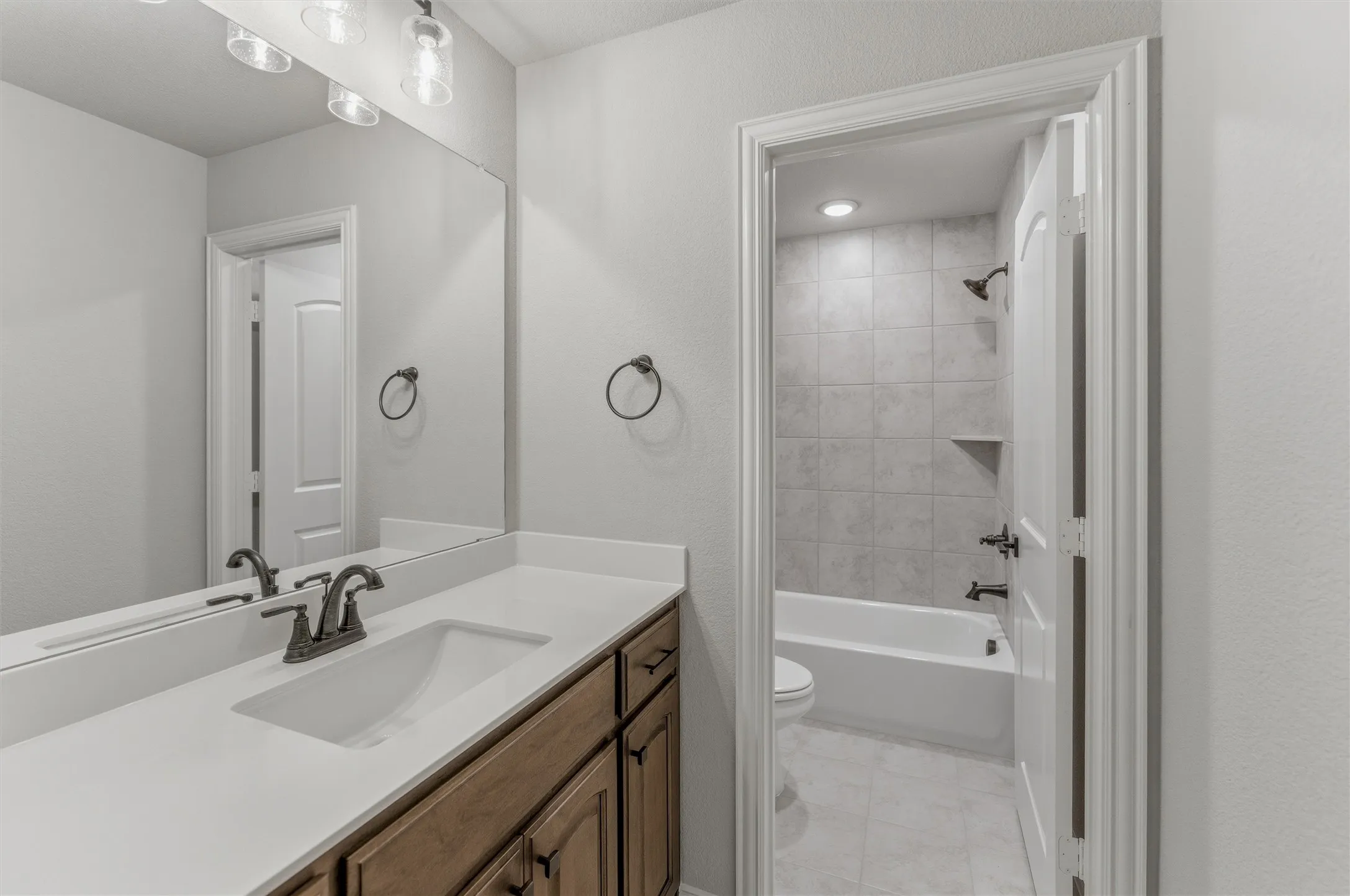 Bathroom vanity featuring a single undermount sink and a light-toned countertop