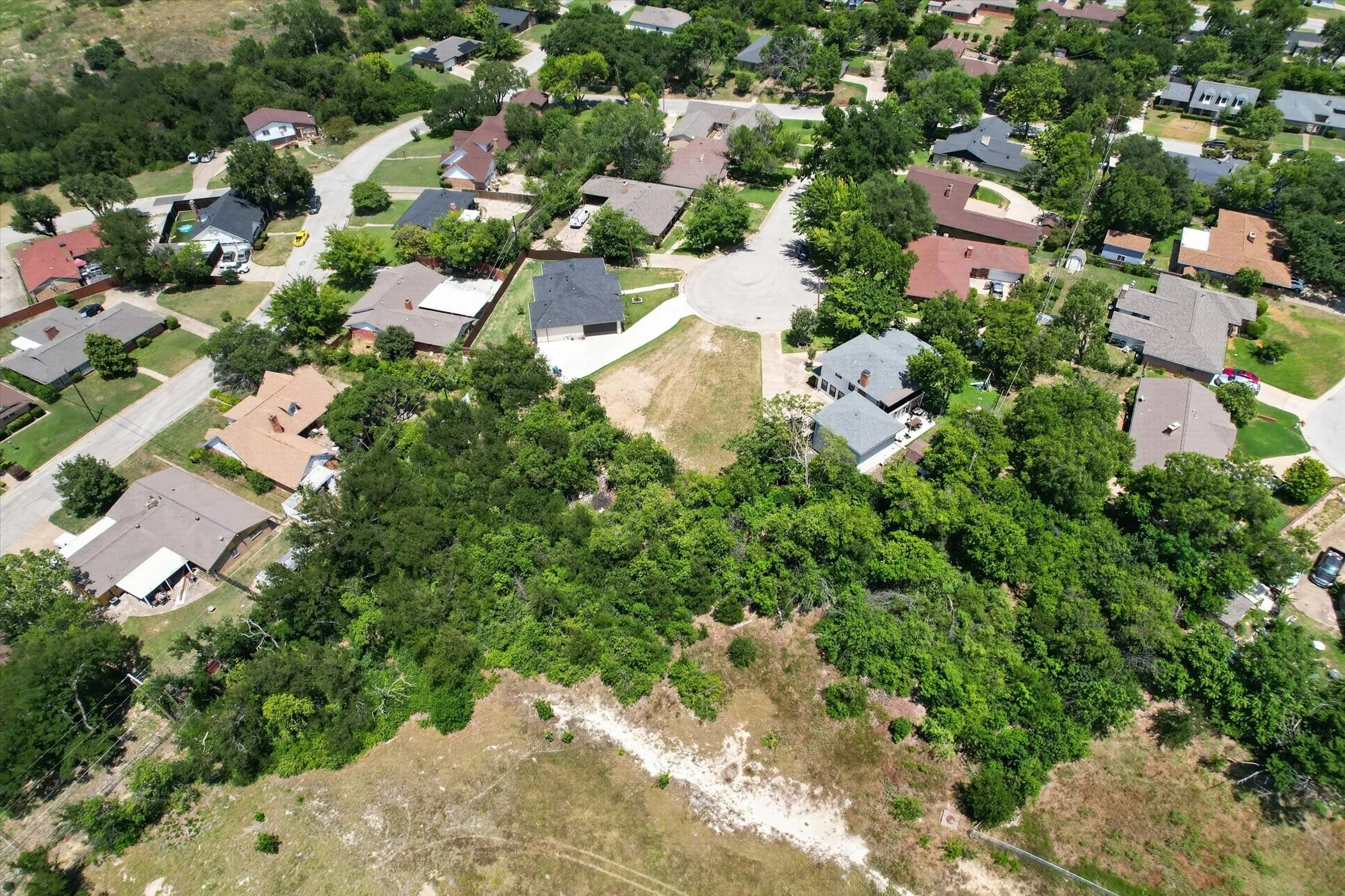 Aerial perspective showcasing a residential neighborhood with established homes and mature trees