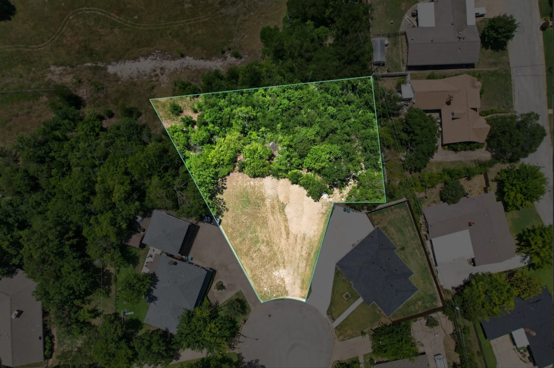 Aerial perspective of a cul-de-sac lot featuring a partial tree canopy