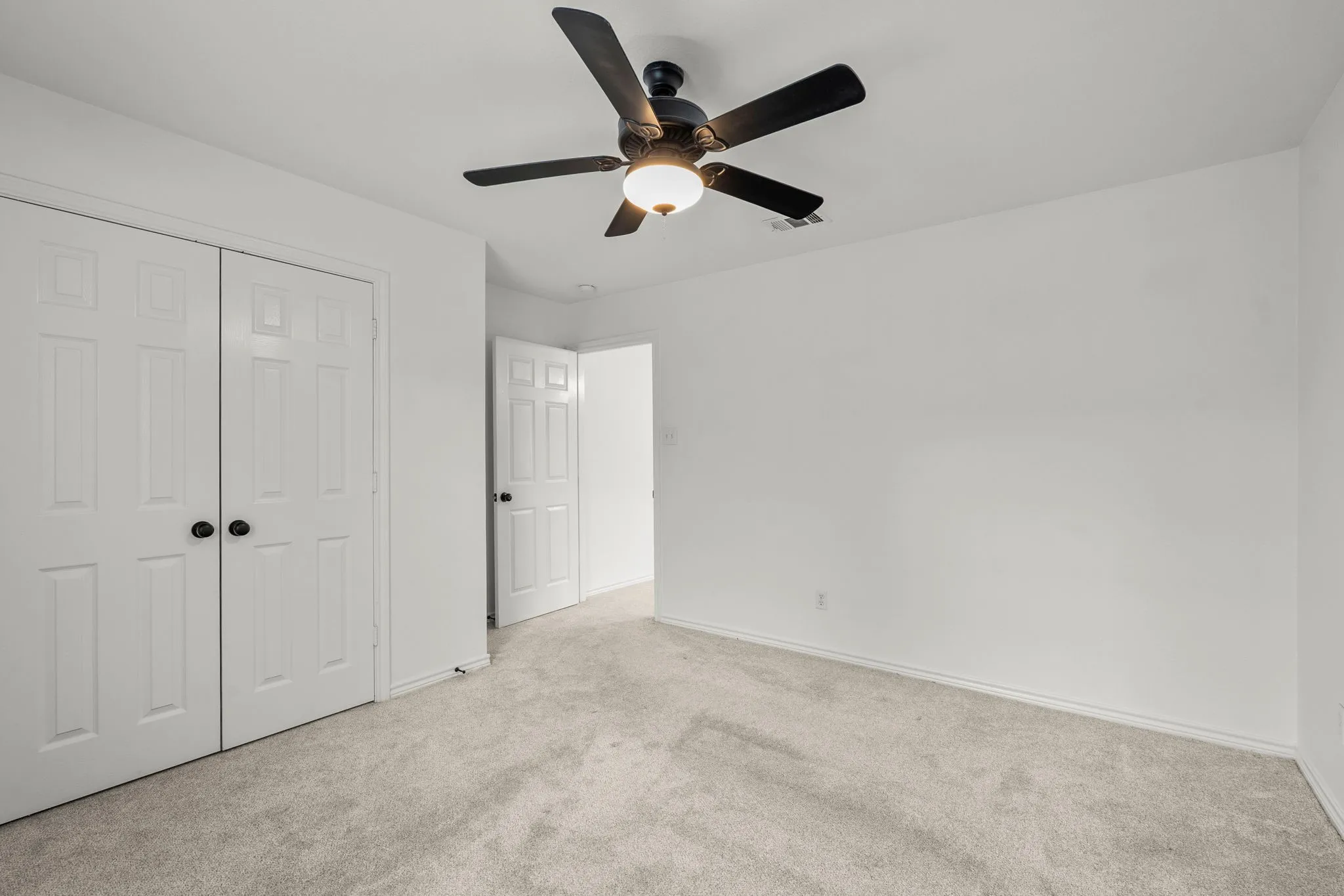 Unfurnished bedroom with carpet flooring, a closet, and ceiling fan