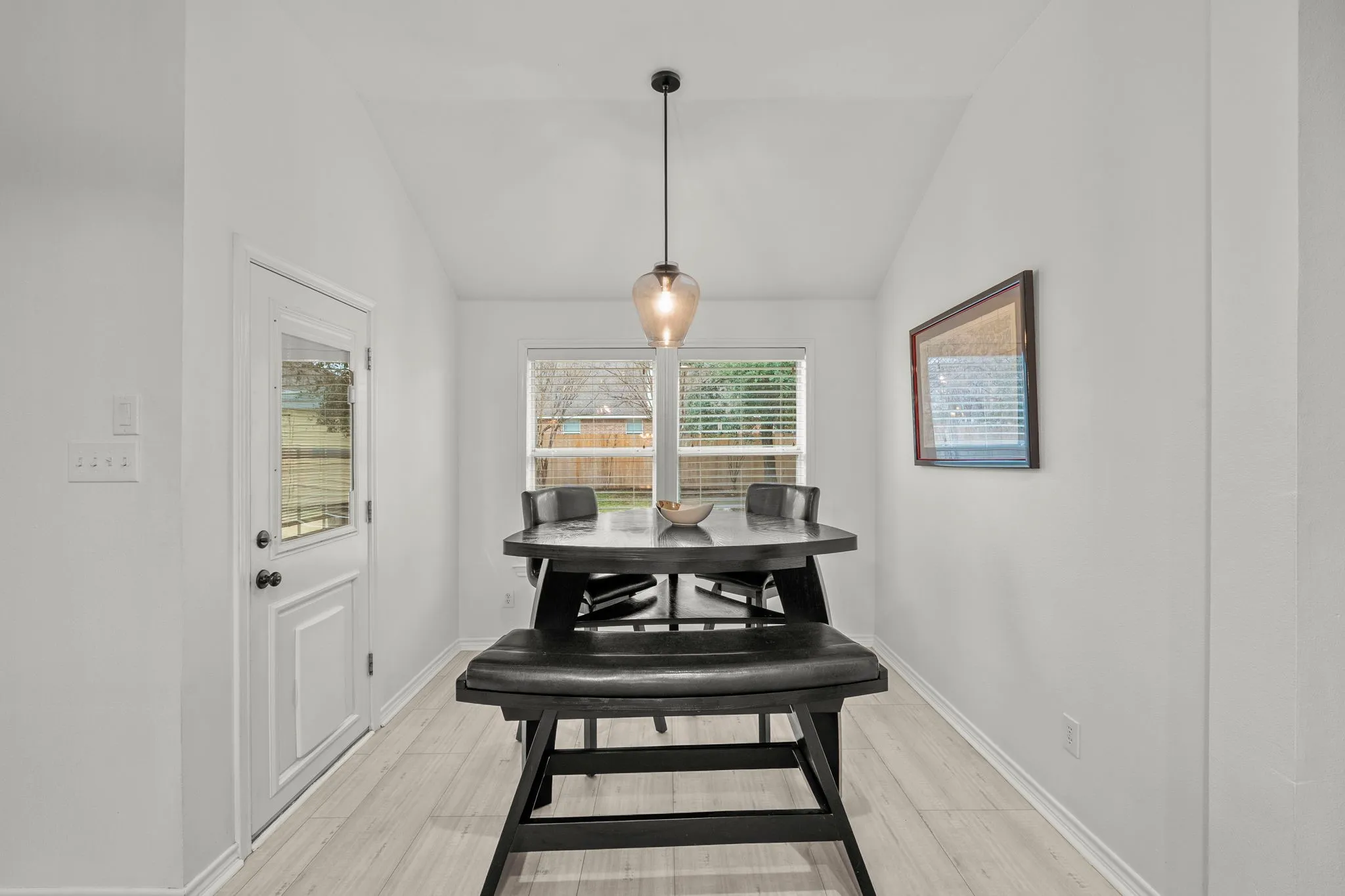 Dining area featuring lofted ceiling and light wood-style flooring
