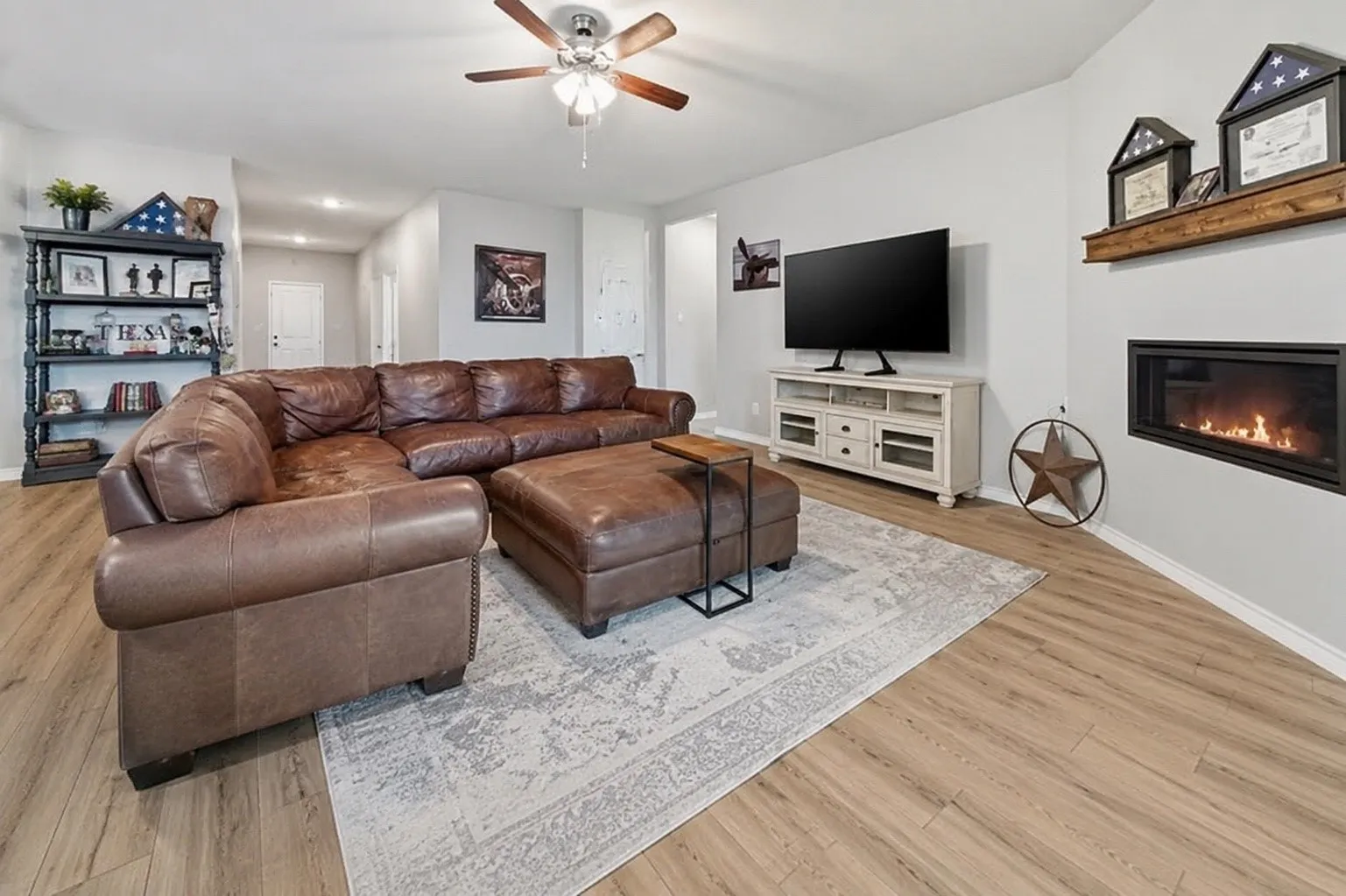 Spacious living area featuring wood-finish flooring, a ceiling fan, and recessed lighting