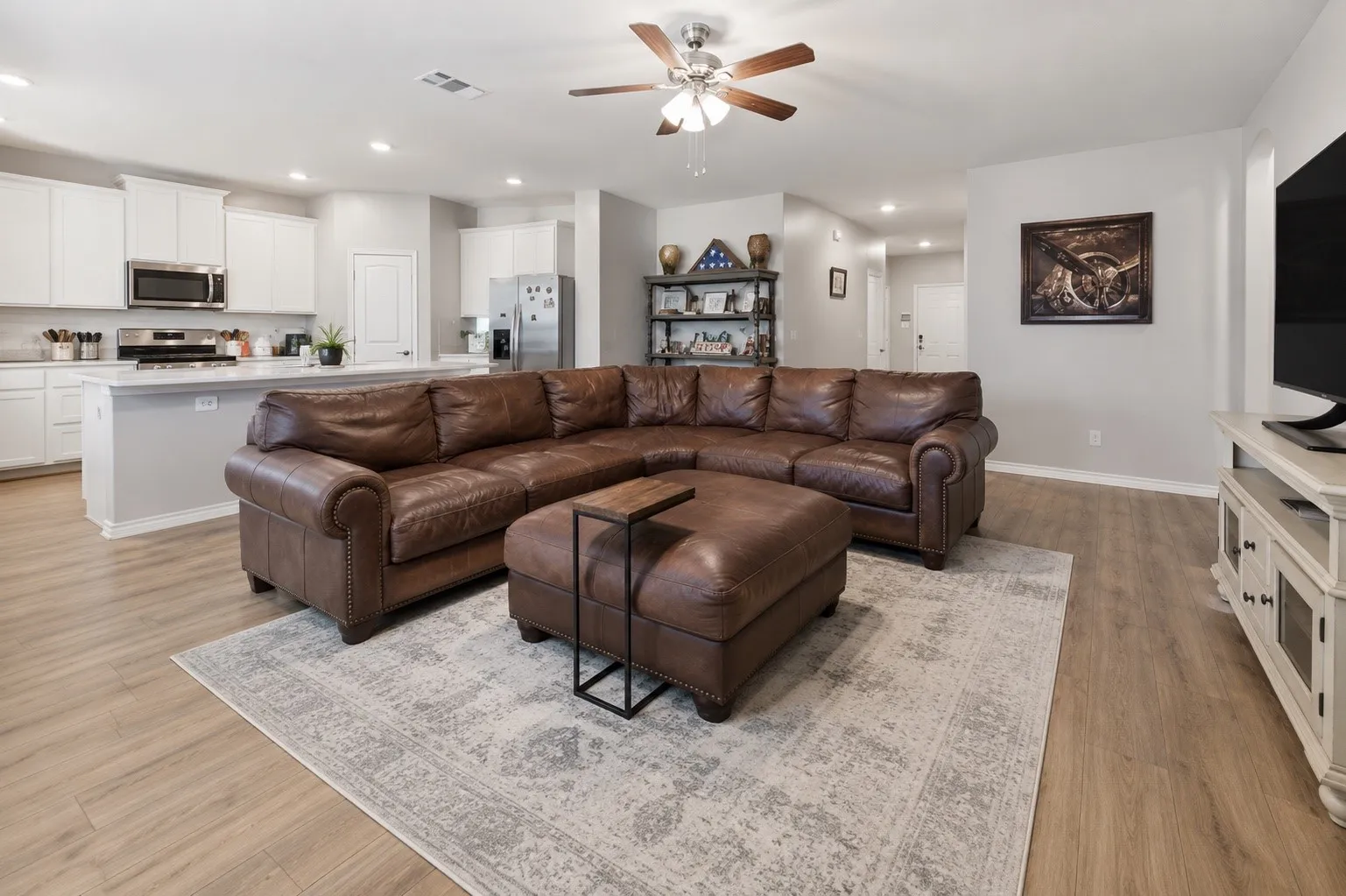 Open-concept living area with wood-finish flooring extending into the kitchen