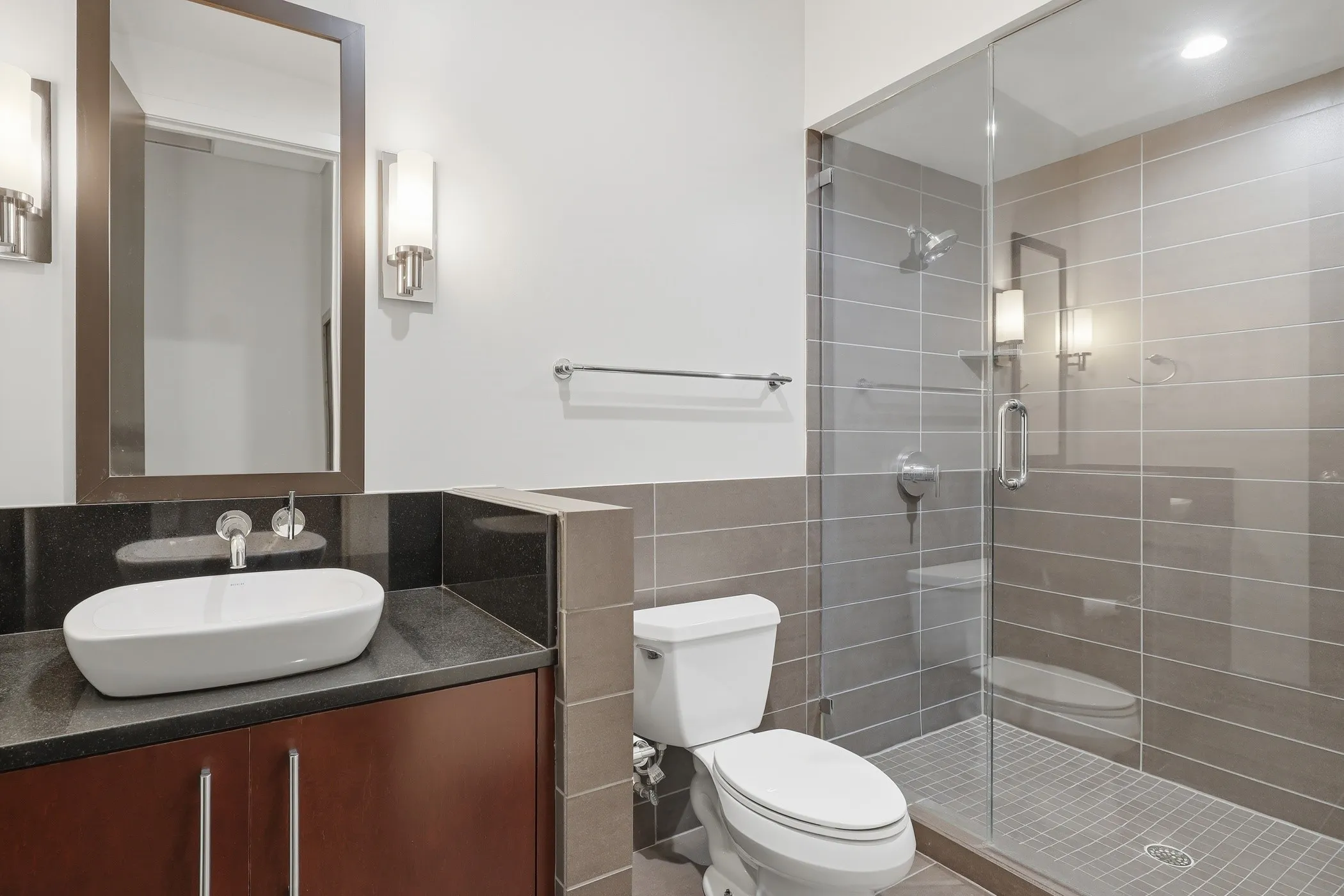 Full bathroom with vanity, a shower stall, and tile walls