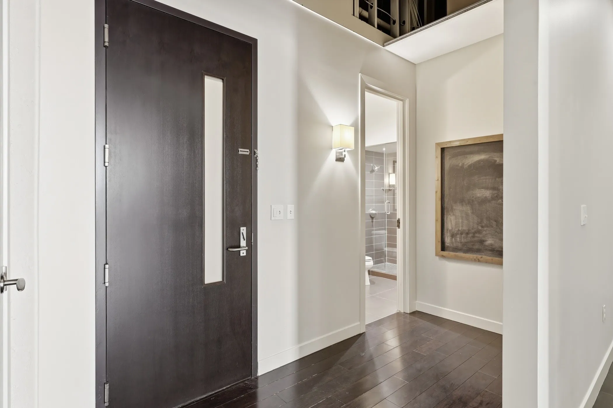 Corridor with dark wood-style flooring and baseboards
