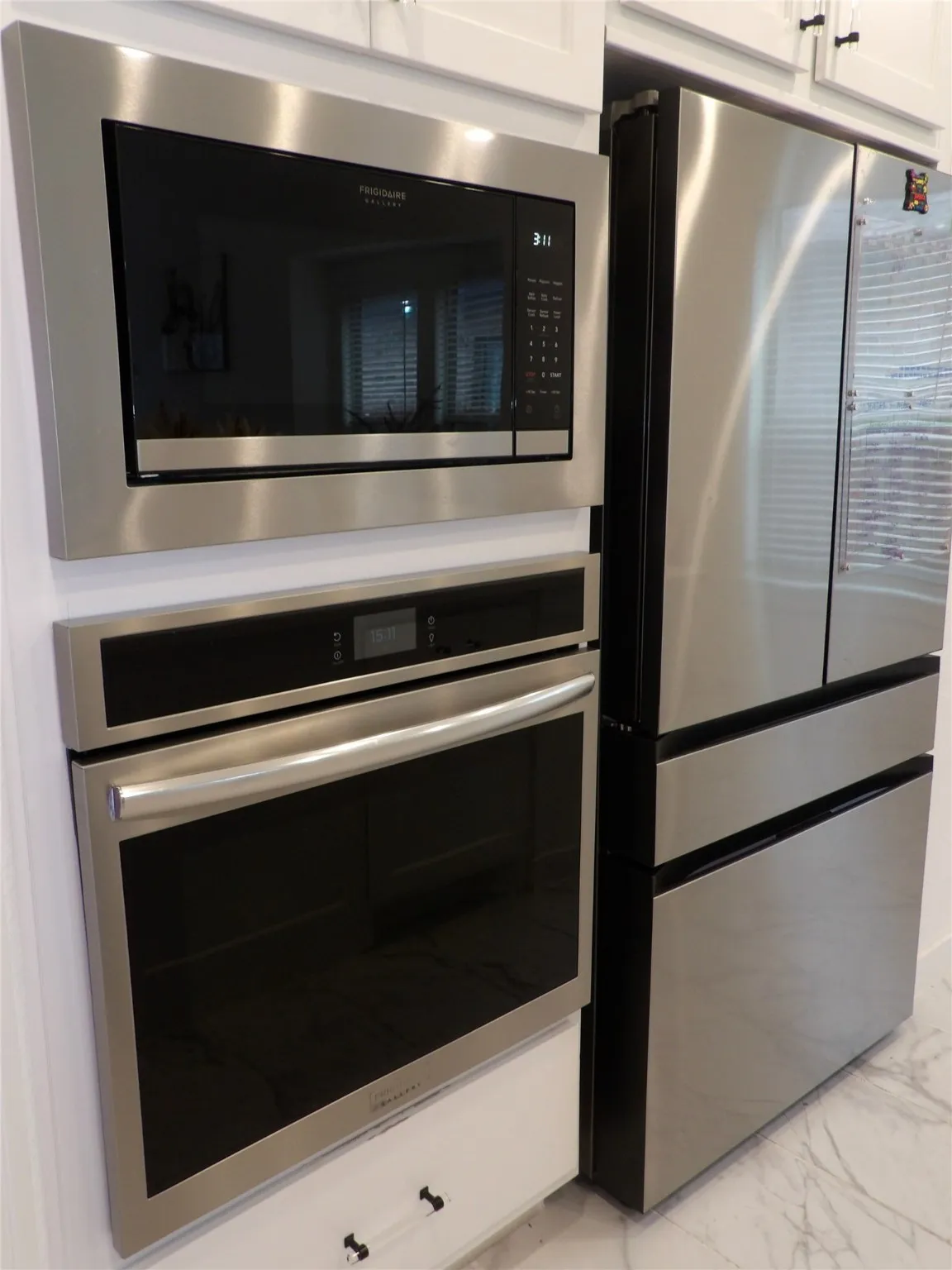 Kitchen view of stainless steel appliances and white cabinetry