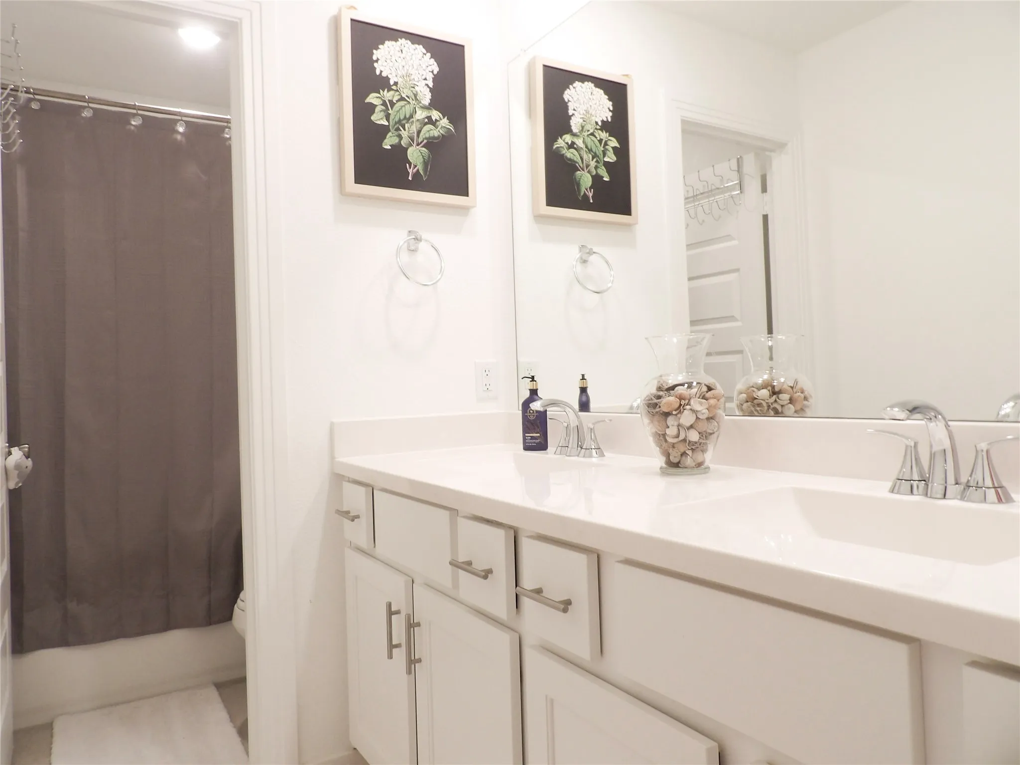Bathroom with double vanity and shower / bath combo with shower curtain