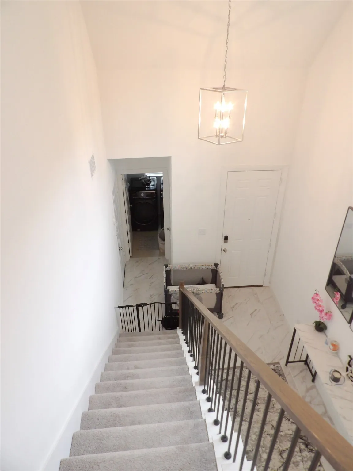 Stairs with a chandelier and a towering ceiling