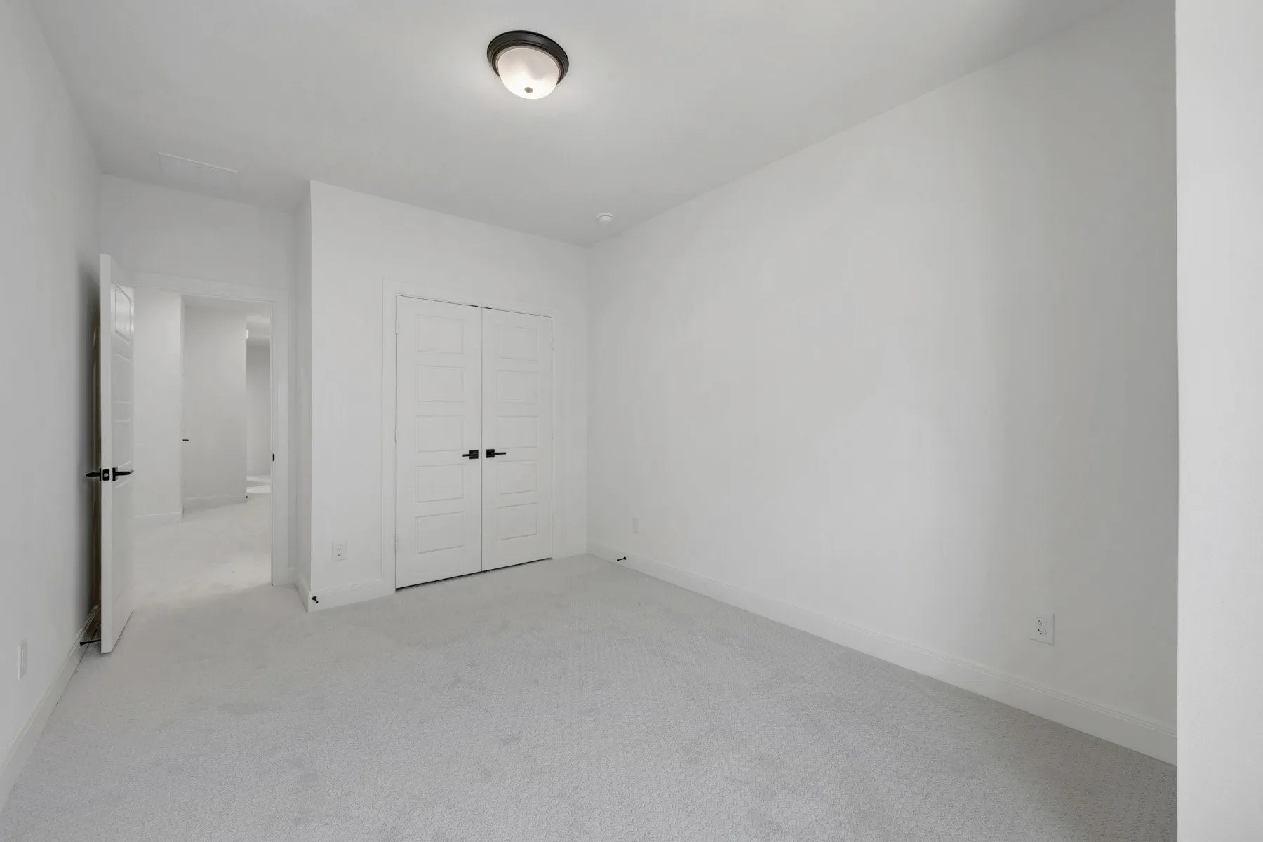 Light gray patterned carpeting, white baseboards, and white walls create a neutral palette