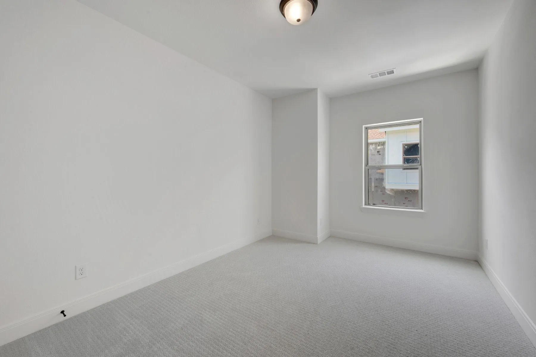 Room featuring light gray carpet flooring, white painted walls, a single window, white baseboards, and an overhead flush-mount light fixture
