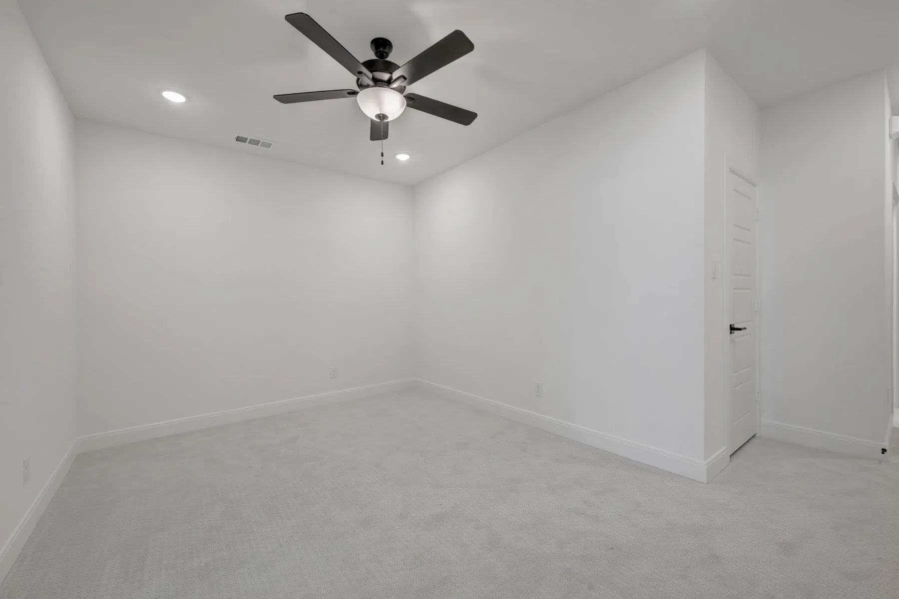 Room featuring light gray carpet, white walls, recessed ceiling lighting, and a ceiling fan with integrated light