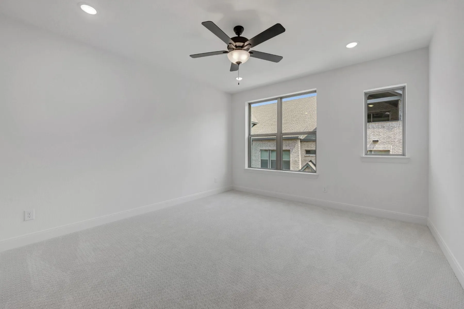 Neutral-toned room featuring light gray carpet, recessed lighting, and a ceiling fan with integrated light