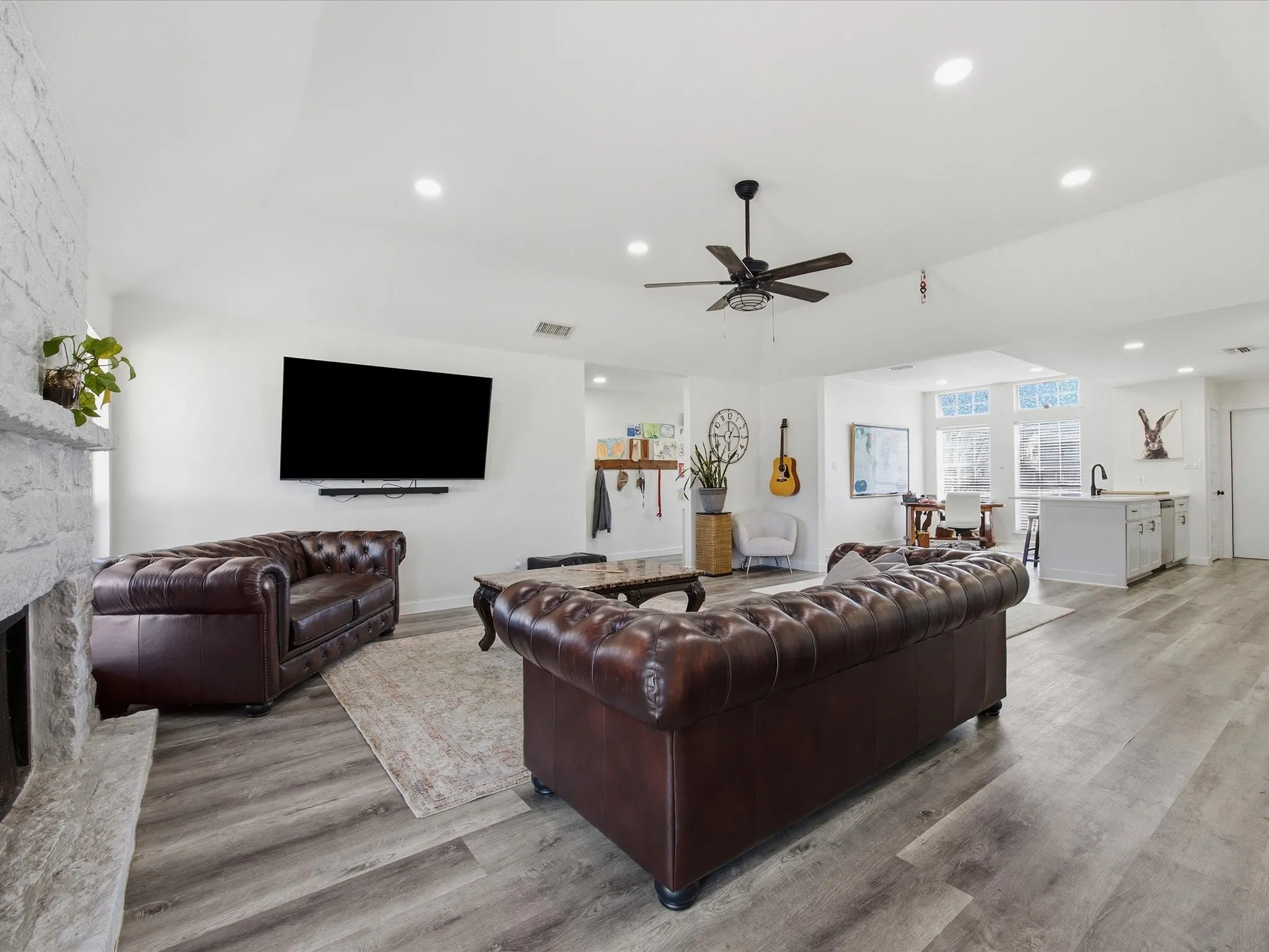 Living area with light wood-type flooring, recessed lighting, ceiling fan, and a fireplace