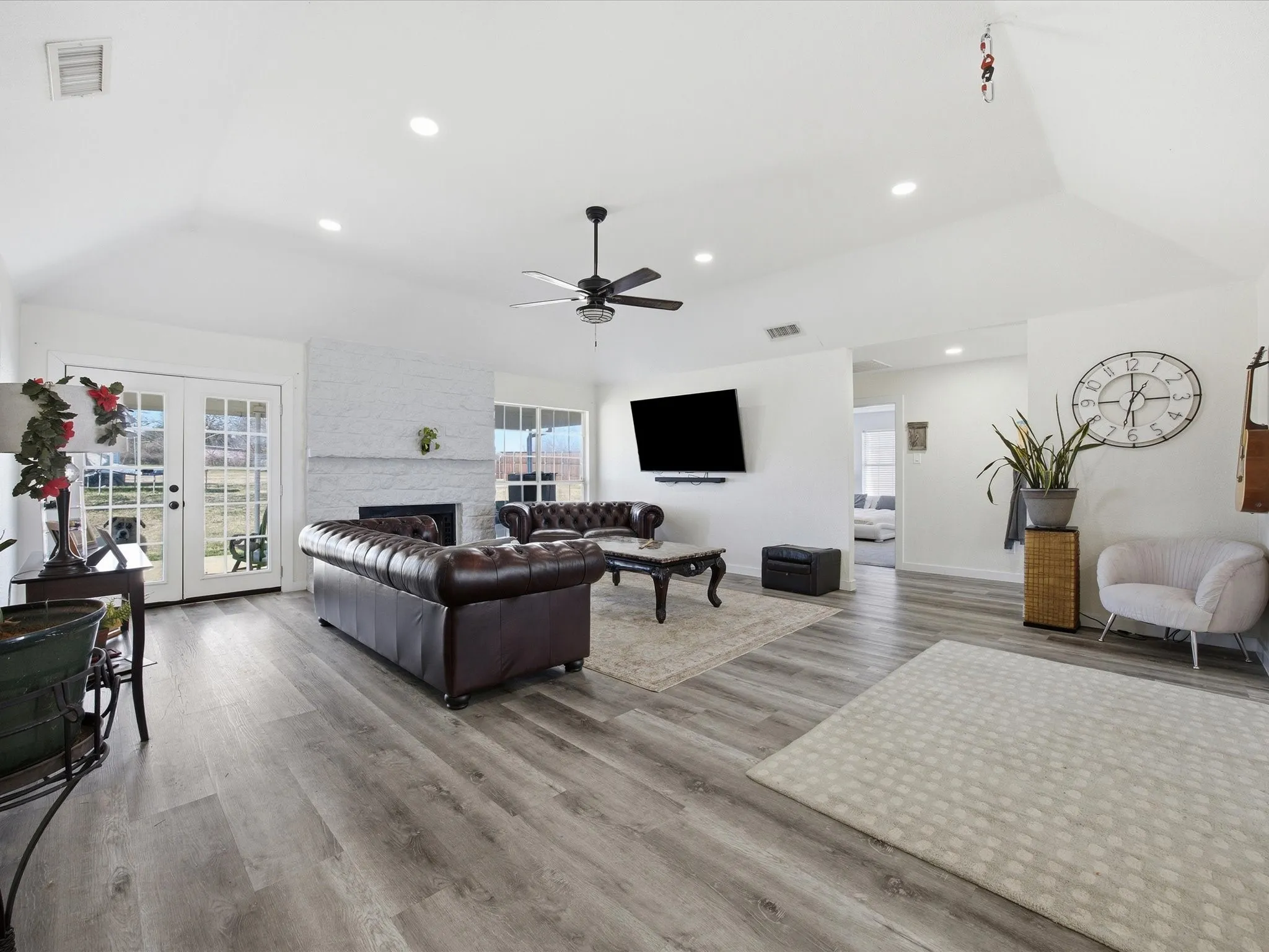 Living area with french doors, vaulted ceiling, light wood-type flooring, recessed lighting, and plenty of natural light