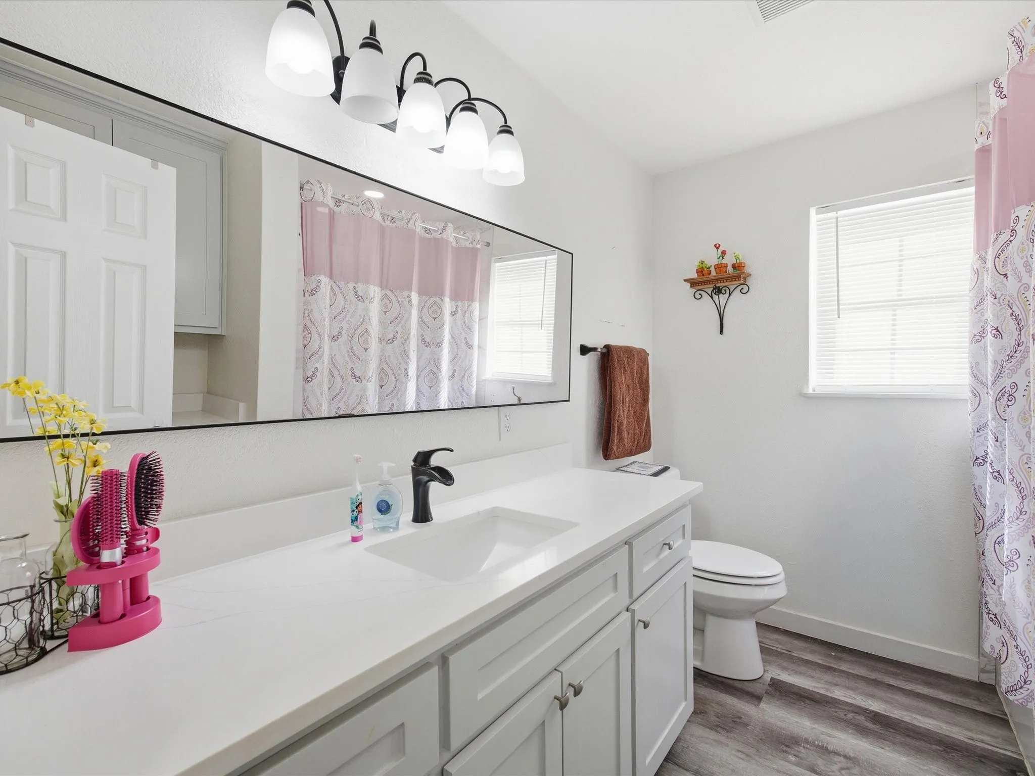Bathroom with vanity, a shower with shower curtain, and dark wood-type flooring